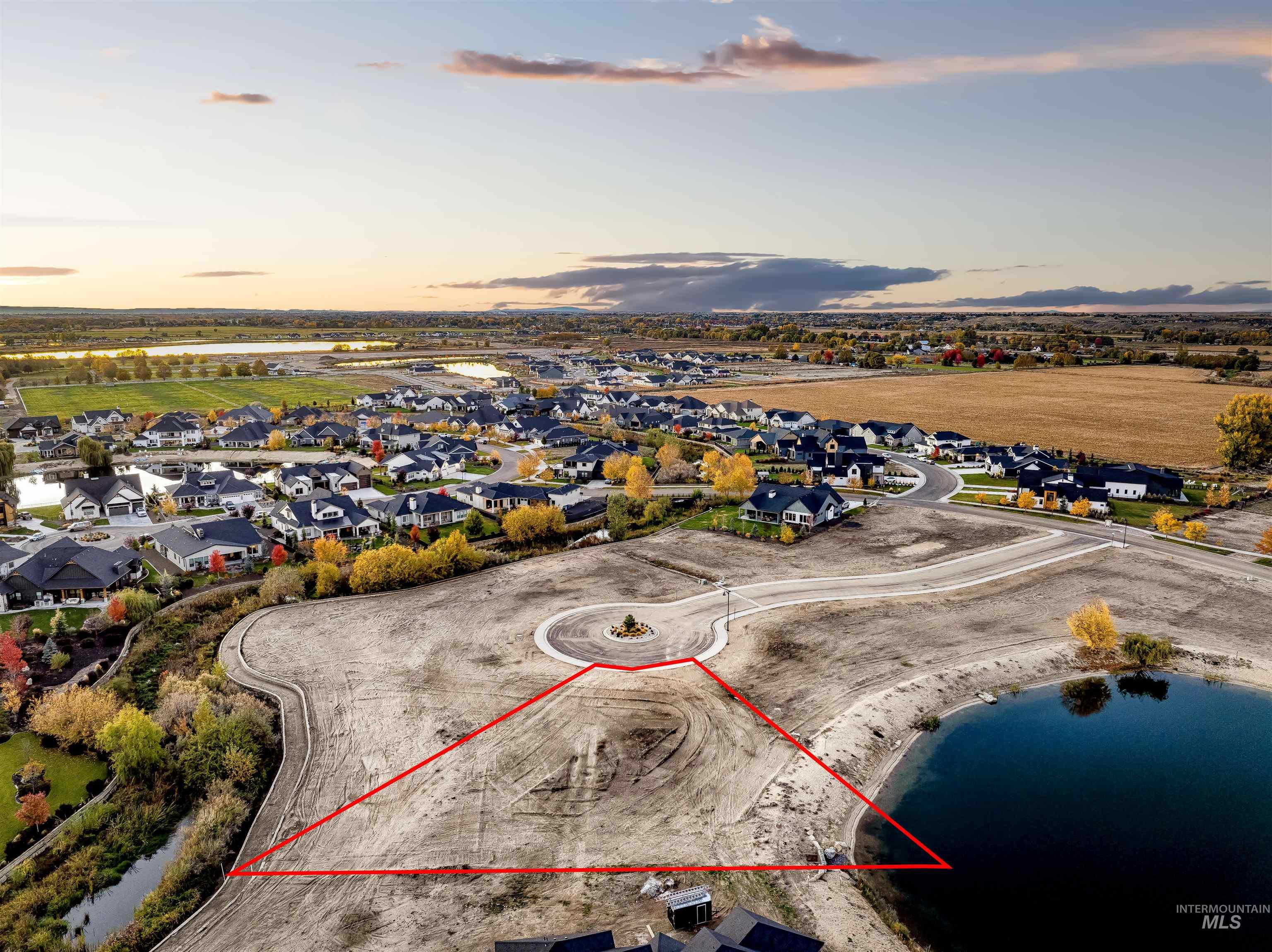 Aerial view at dusk of a water view, a residential view, and property boundaries highlighted
