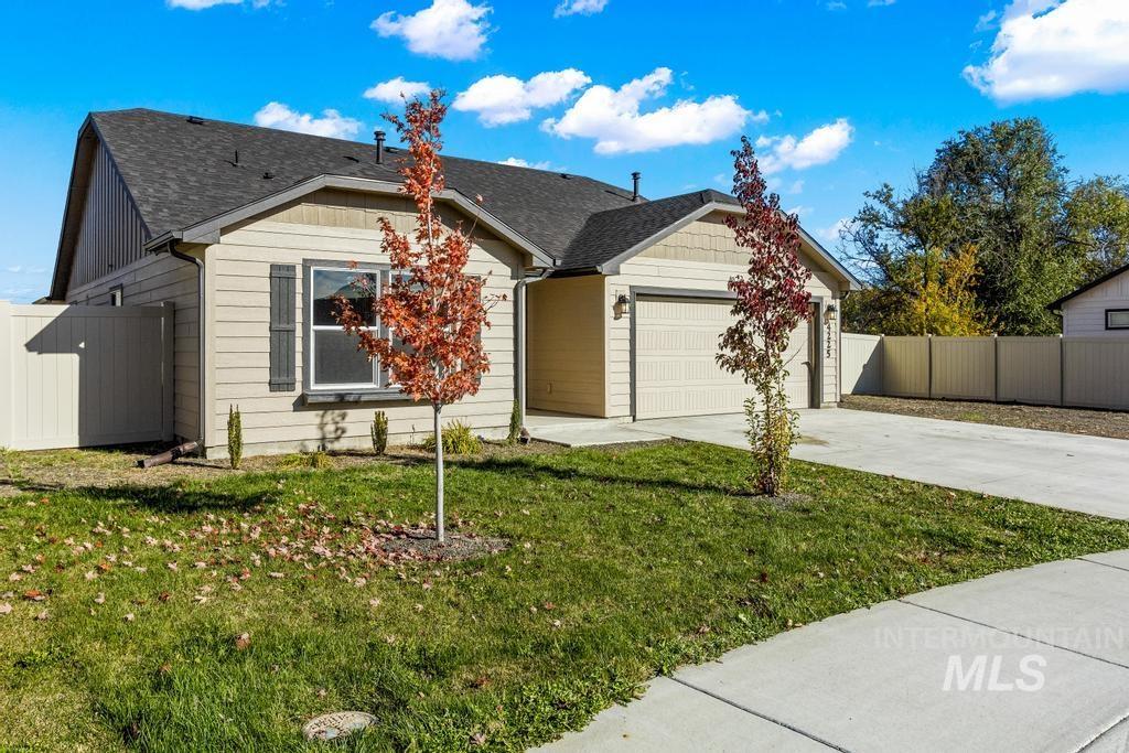 Ranch-style home with concrete driveway, a garage, and a shingled roof