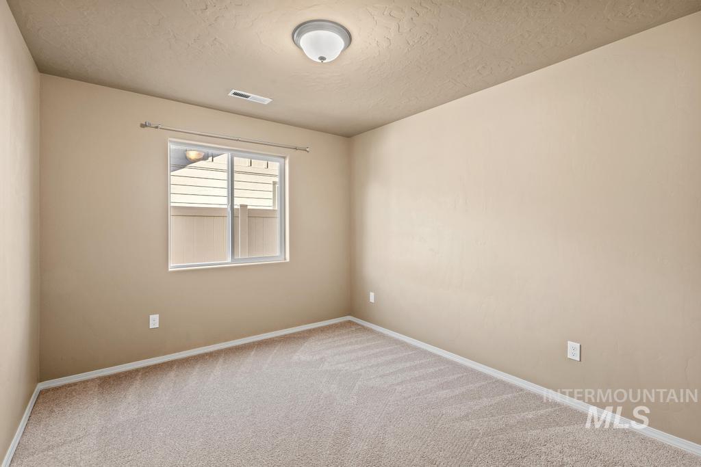 Empty room with carpet and a textured ceiling