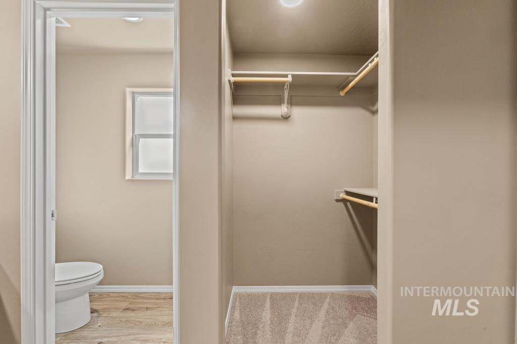 Spacious closet featuring light wood-style flooring