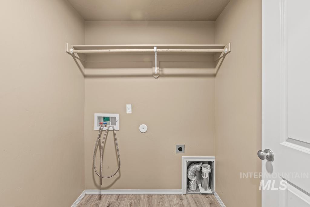 Laundry area featuring wood finished floors, electric dryer hookup, washer hookup, and hookup for a gas dryer