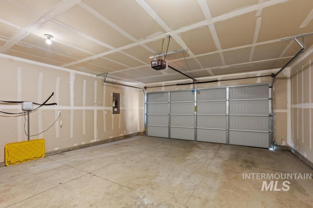 Garage featuring electric panel and a garage door opener
