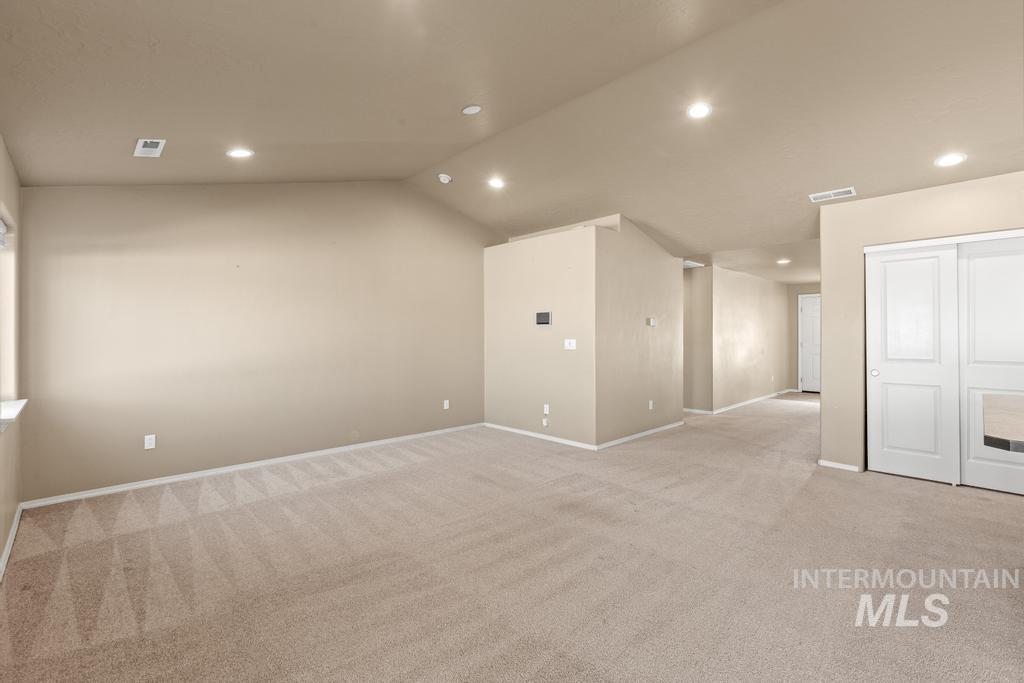 Carpeted spare room featuring recessed lighting and lofted ceiling