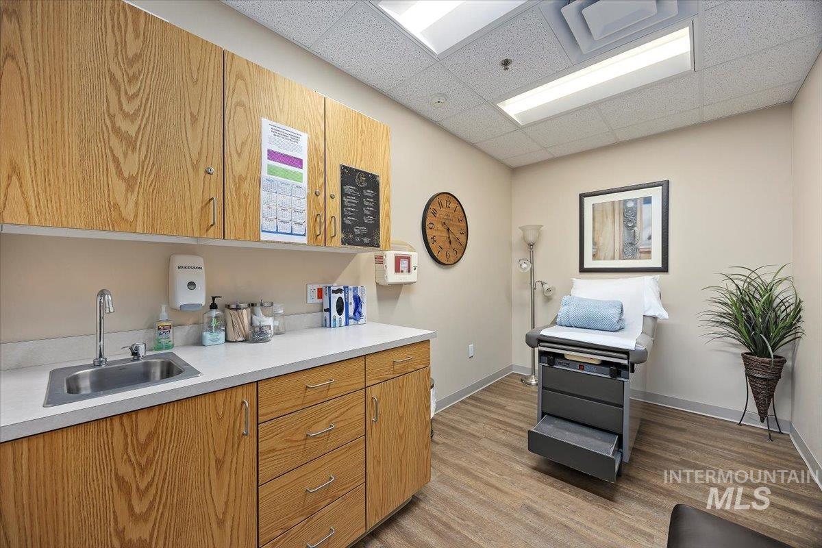 Kitchen featuring a drop ceiling, light countertops, and brown cabinets