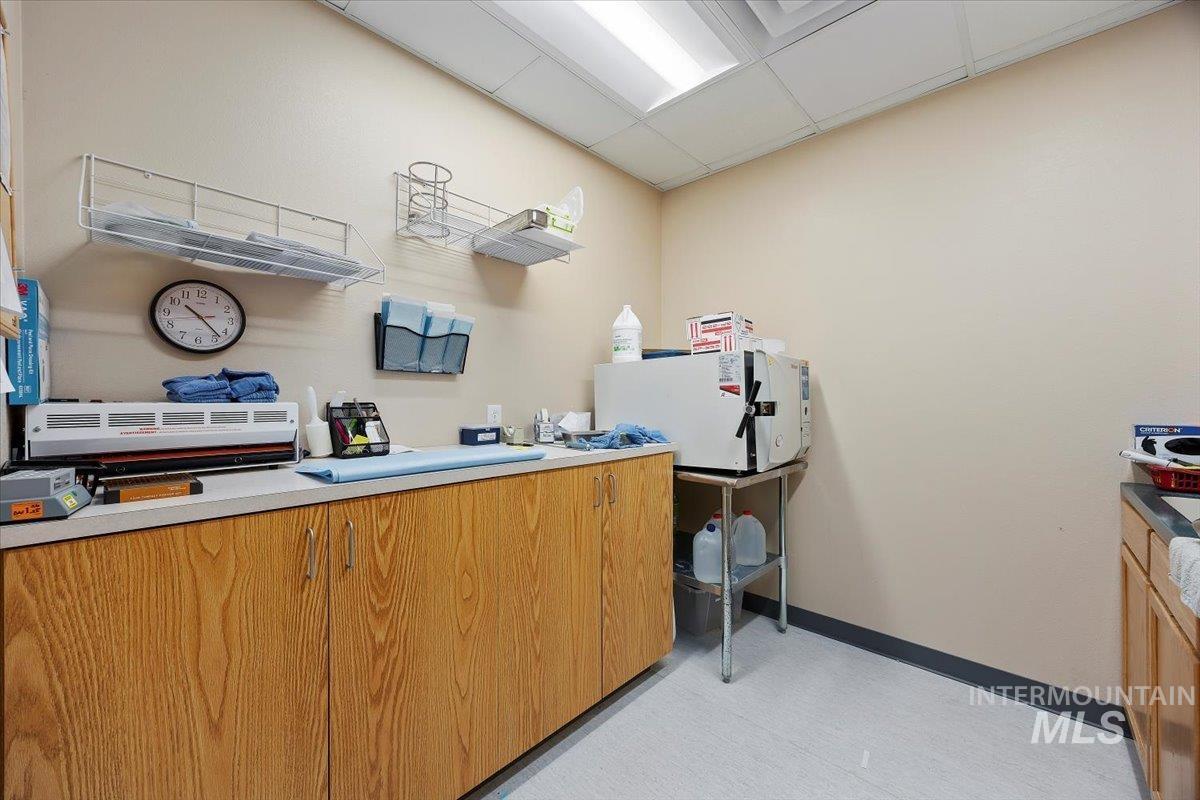 Kitchen with a drop ceiling and light countertops