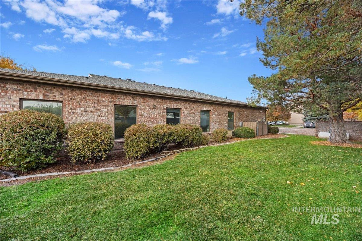 Rear view of house with brick siding and a yard