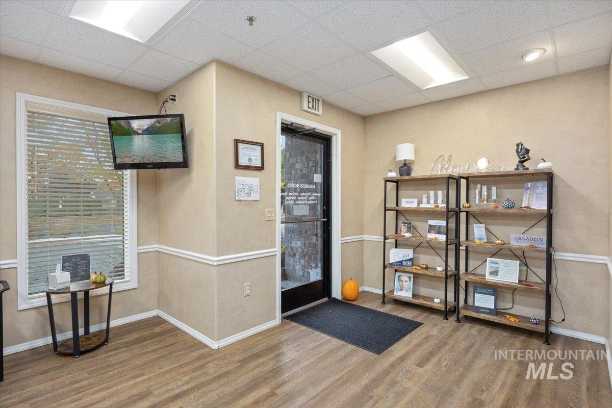 Doorway with a drop ceiling and wood finished floors