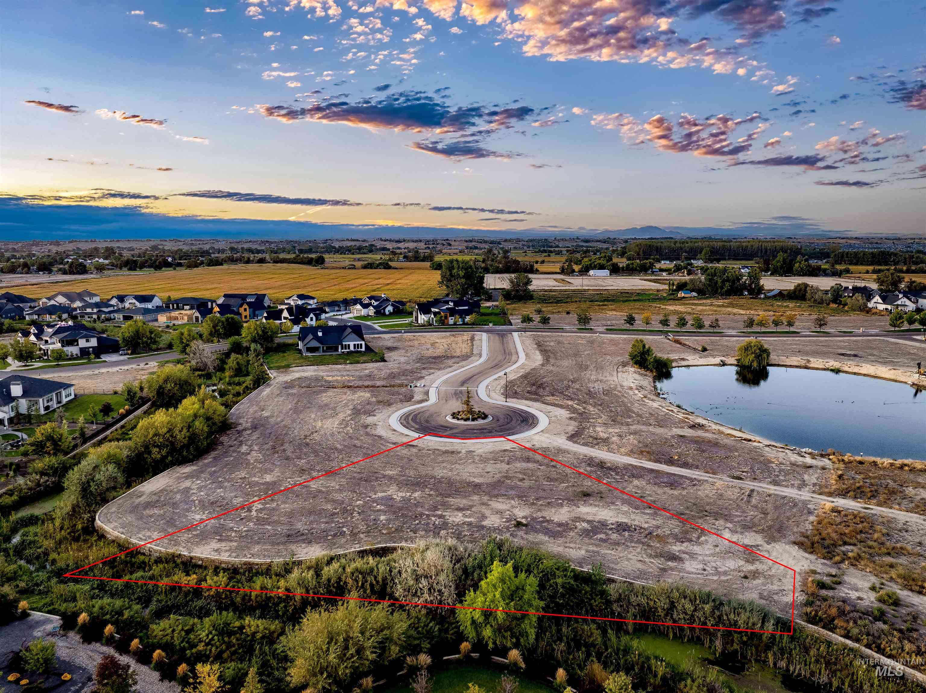 Aerial perspective of suburban area featuring a large body of water and property parcel outlined