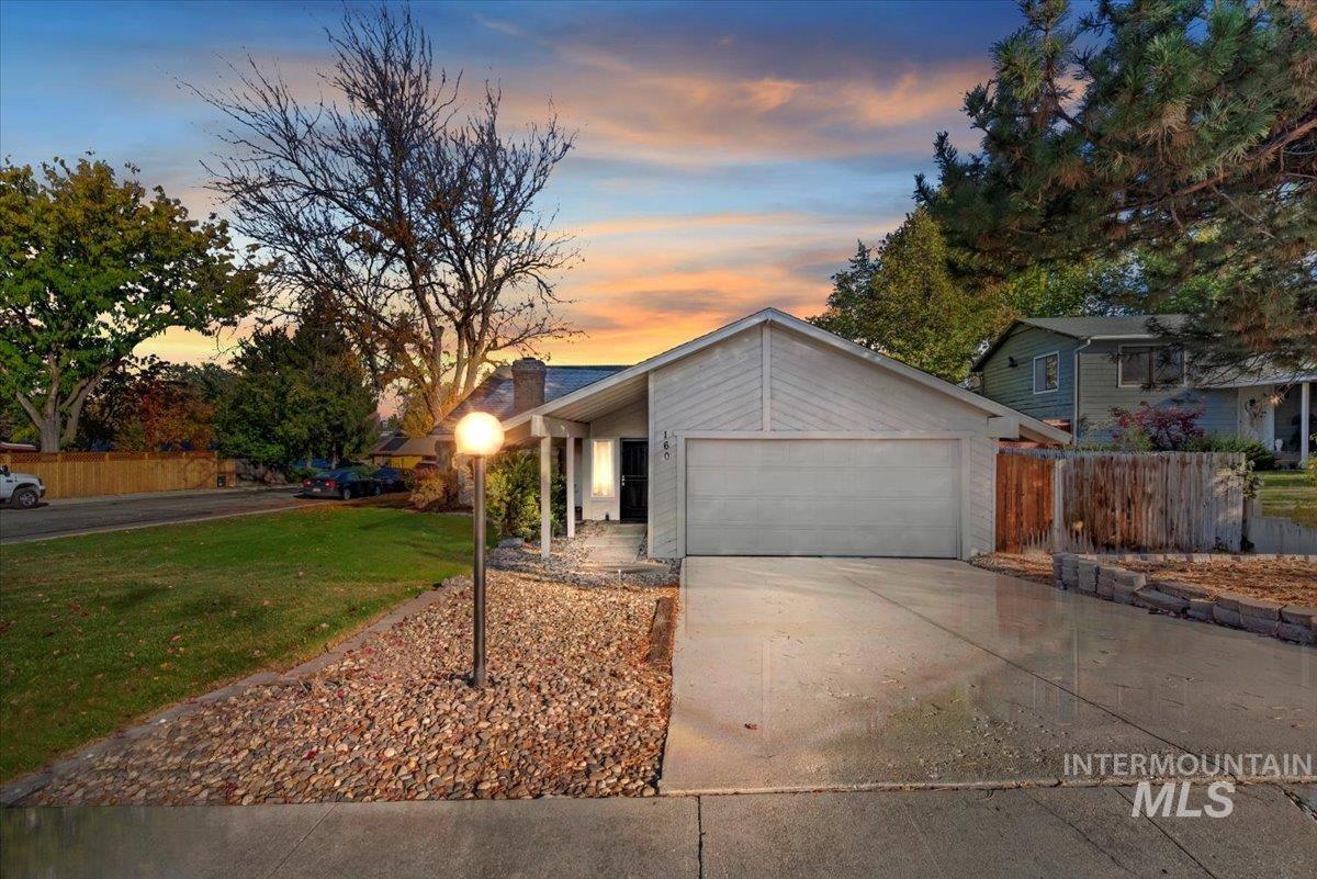 Mid-century home with driveway, an attached garage, and a chimney