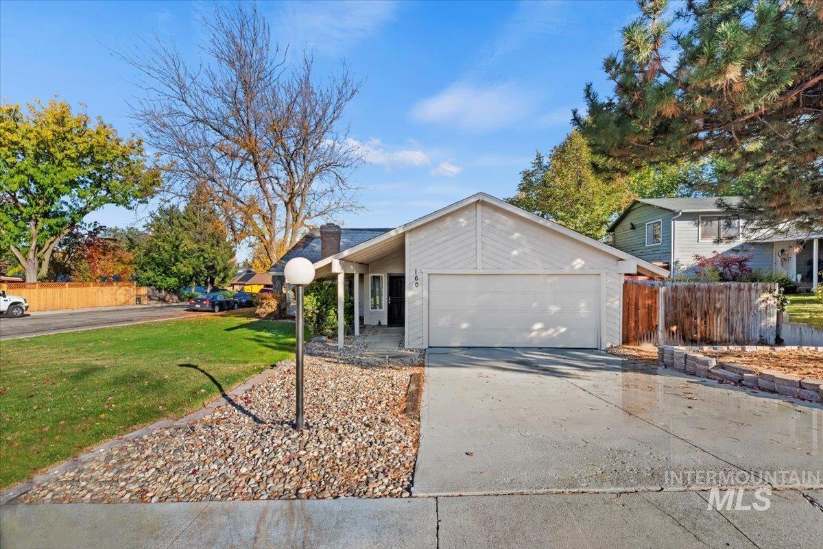 View of front of property featuring concrete driveway, a garage, and a chimney