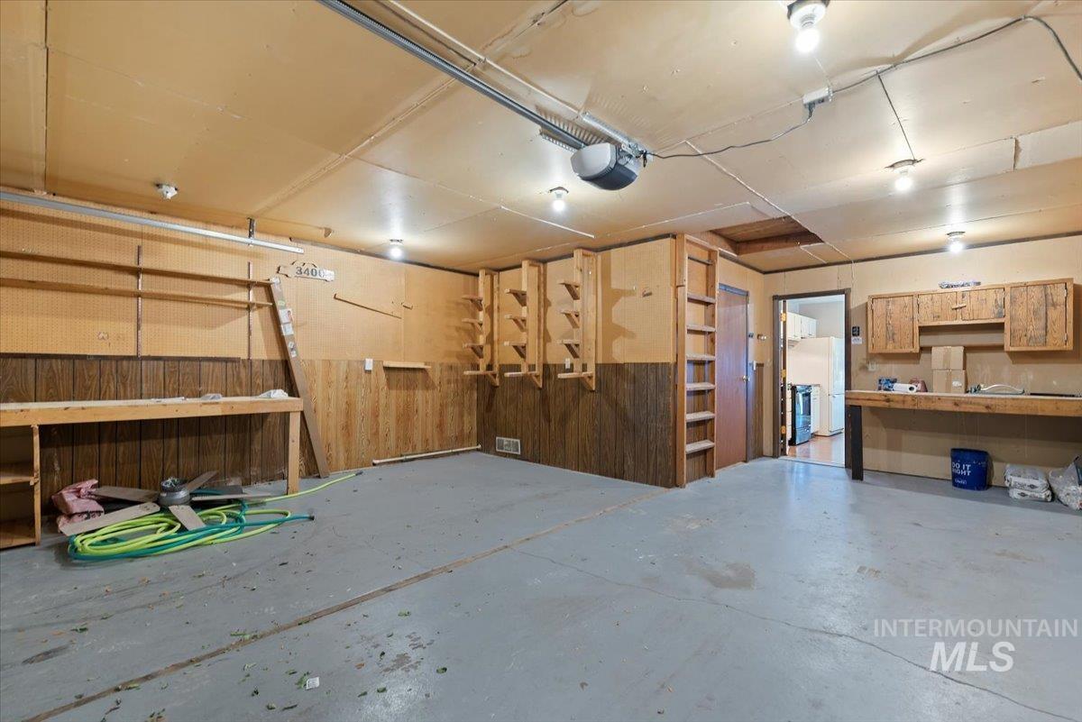 Garage featuring wood walls and a garage door opener