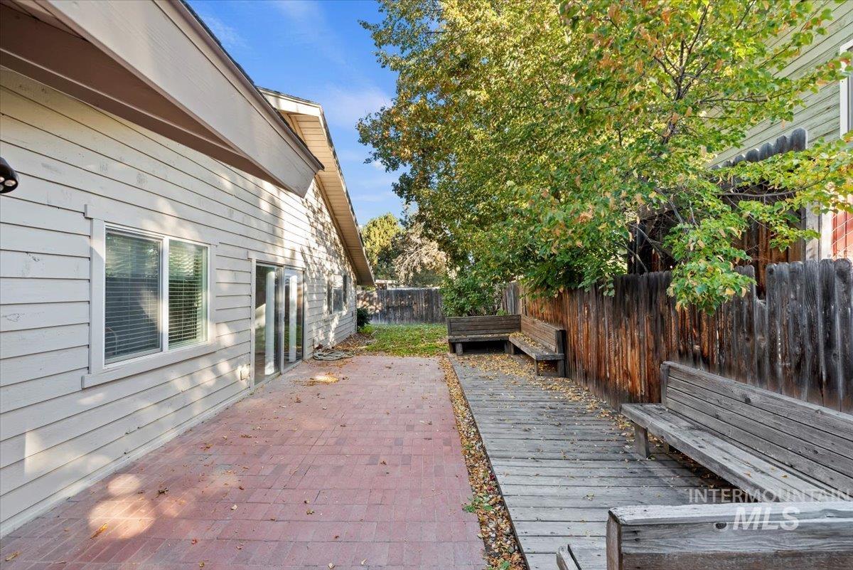 Wooden terrace featuring a fenced backyard and a patio