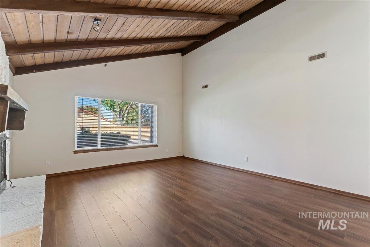 Unfurnished living room with dark wood-style flooring, a fireplace, high vaulted ceiling, and wooden ceiling