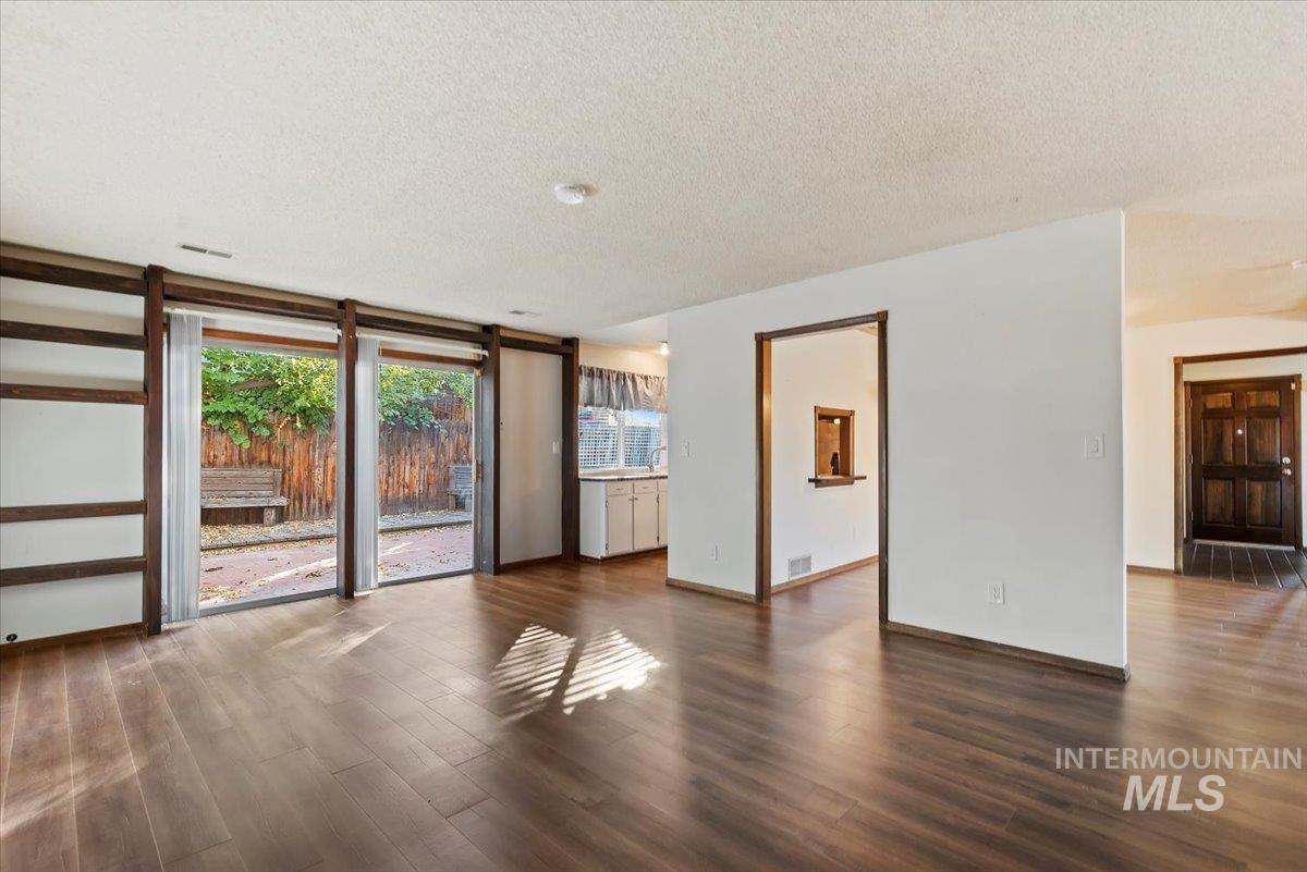 Unfurnished room featuring a textured ceiling and dark wood-style flooring