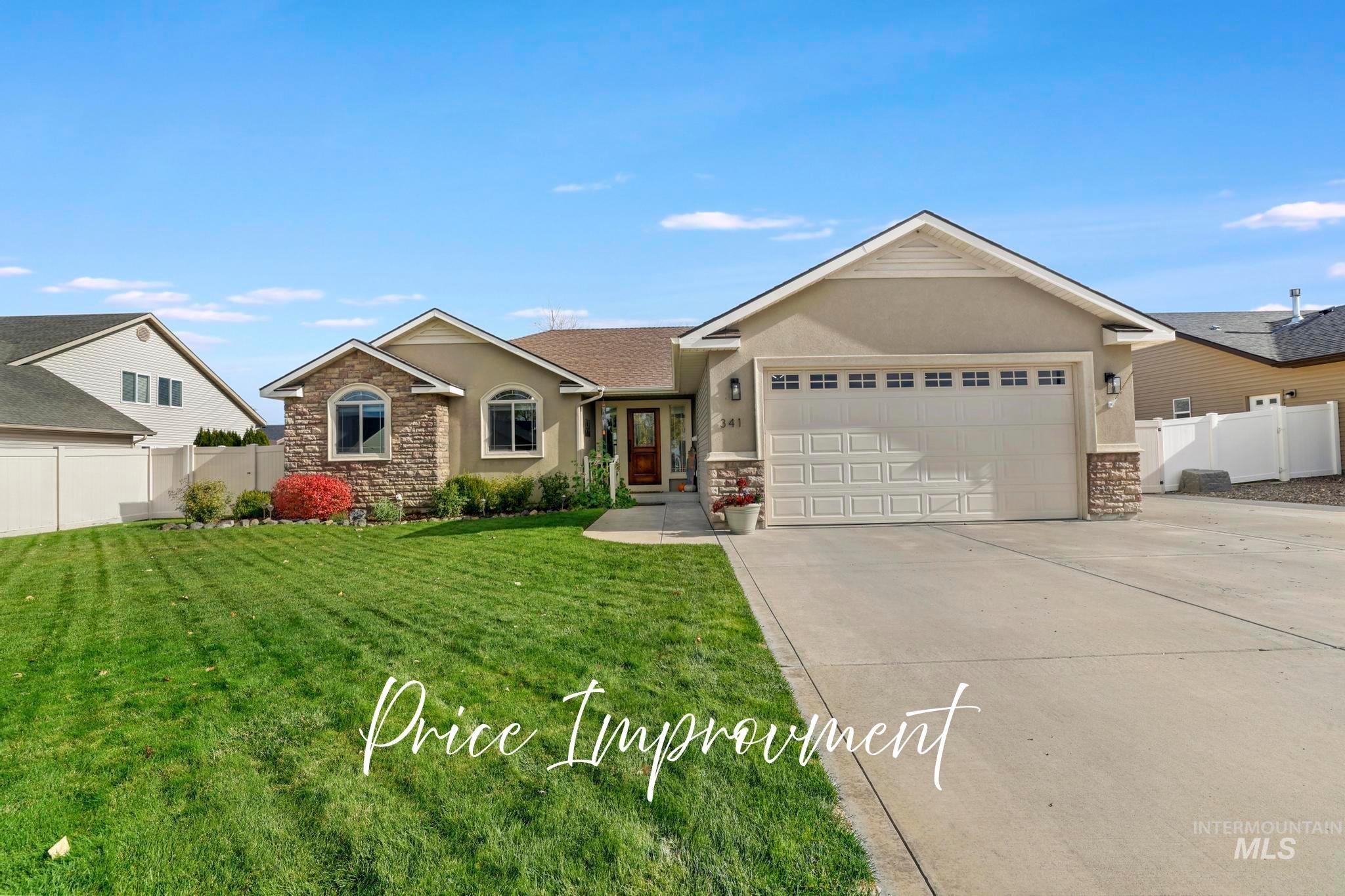 Single story home with stone siding, stucco siding, driveway, and a garage