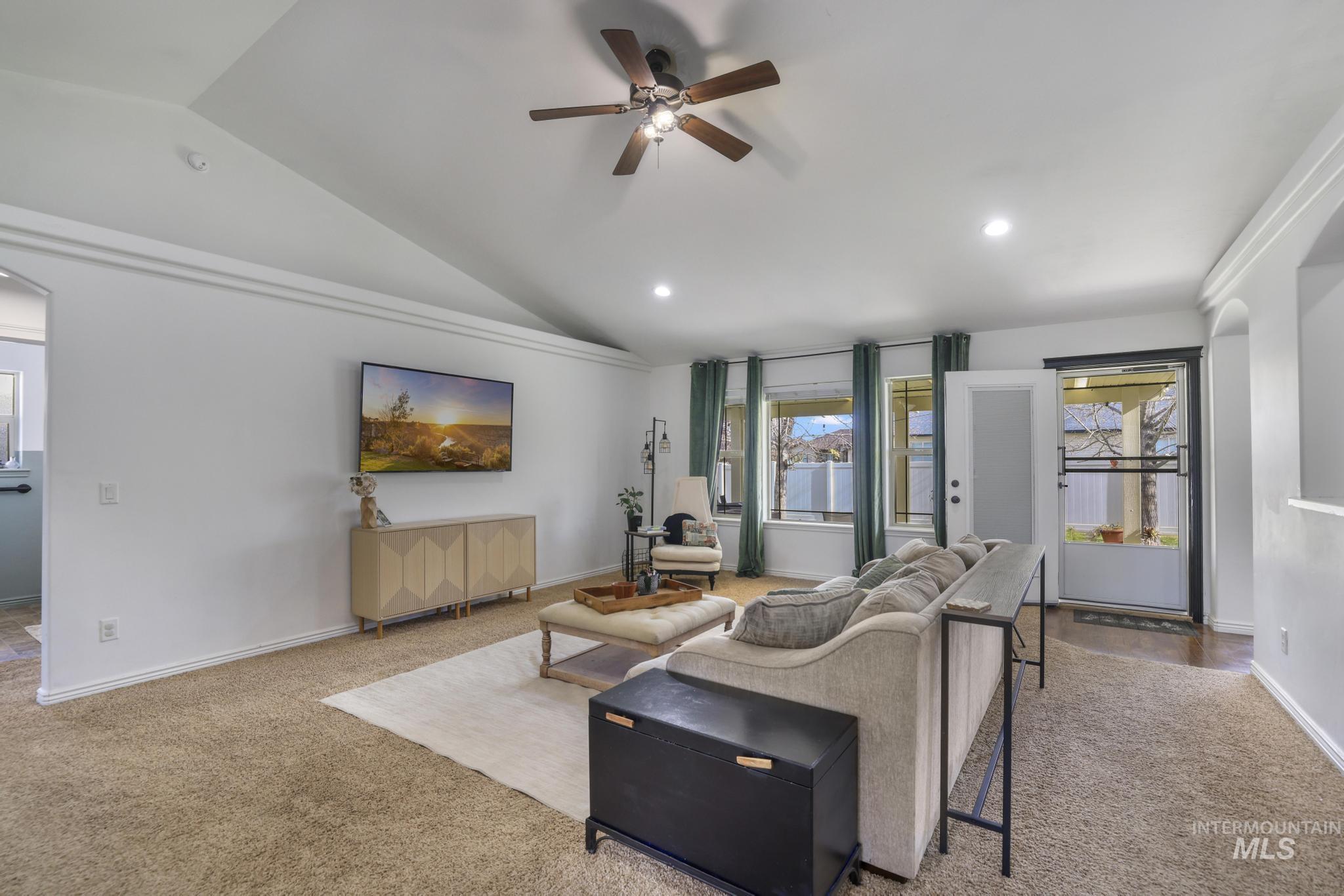 Living area with ceiling fan, lofted ceiling, light colored carpet, and recessed lighting
