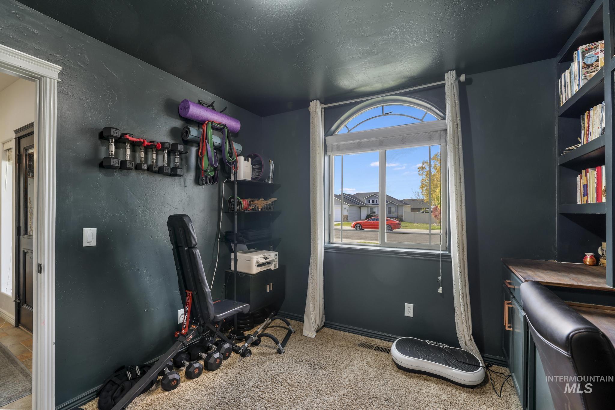 Office space with light carpet, a textured ceiling, and a textured wall