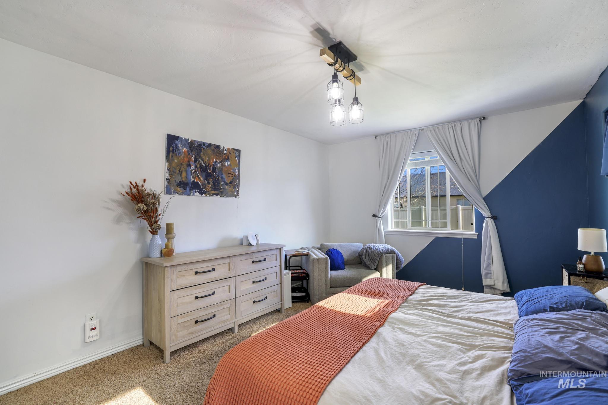Bedroom featuring carpet and baseboards