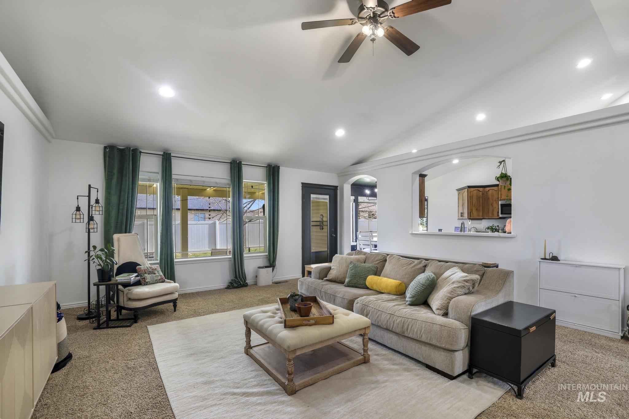 Living room featuring light carpet, recessed lighting, ceiling fan, and vaulted ceiling