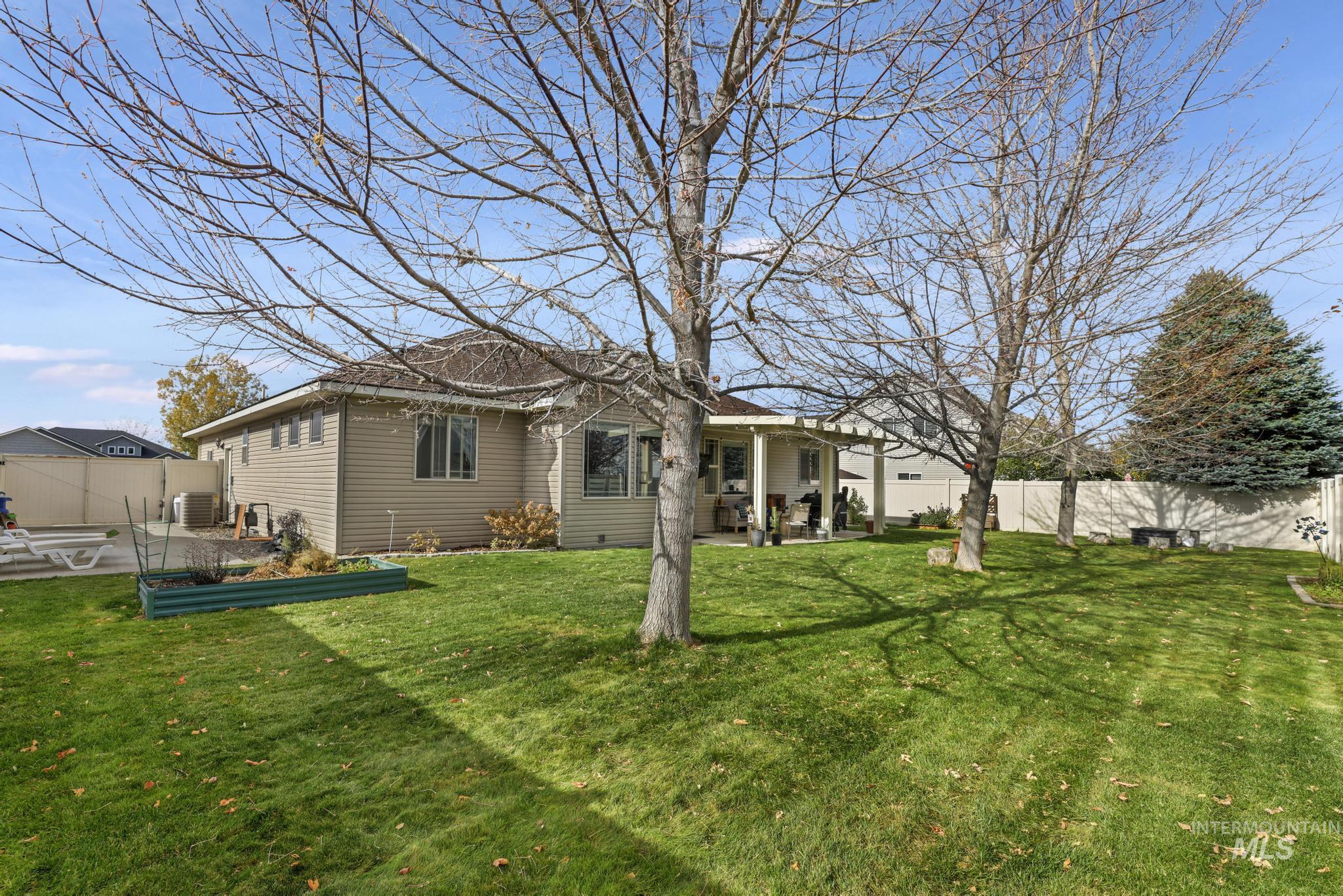 Back of property featuring a patio, a fenced backyard, and a vegetable garden