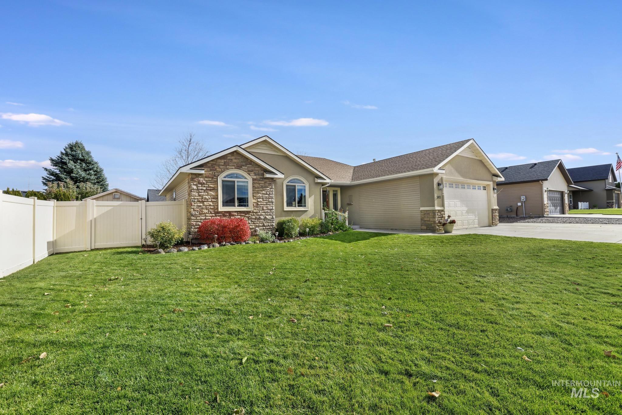 Ranch-style home with stone siding, concrete driveway, a garage, and stucco siding