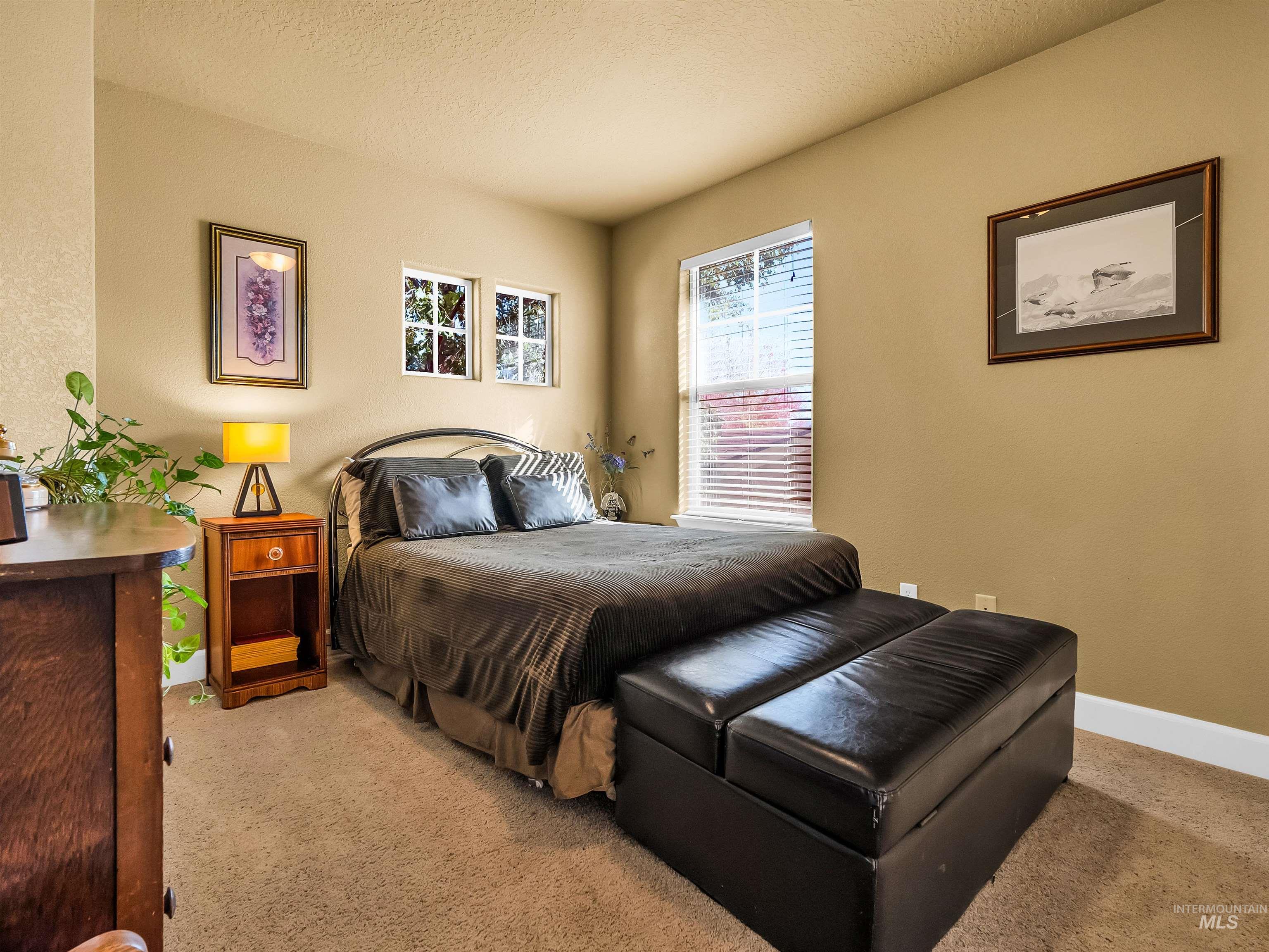 Bedroom with a textured ceiling and light colored carpet