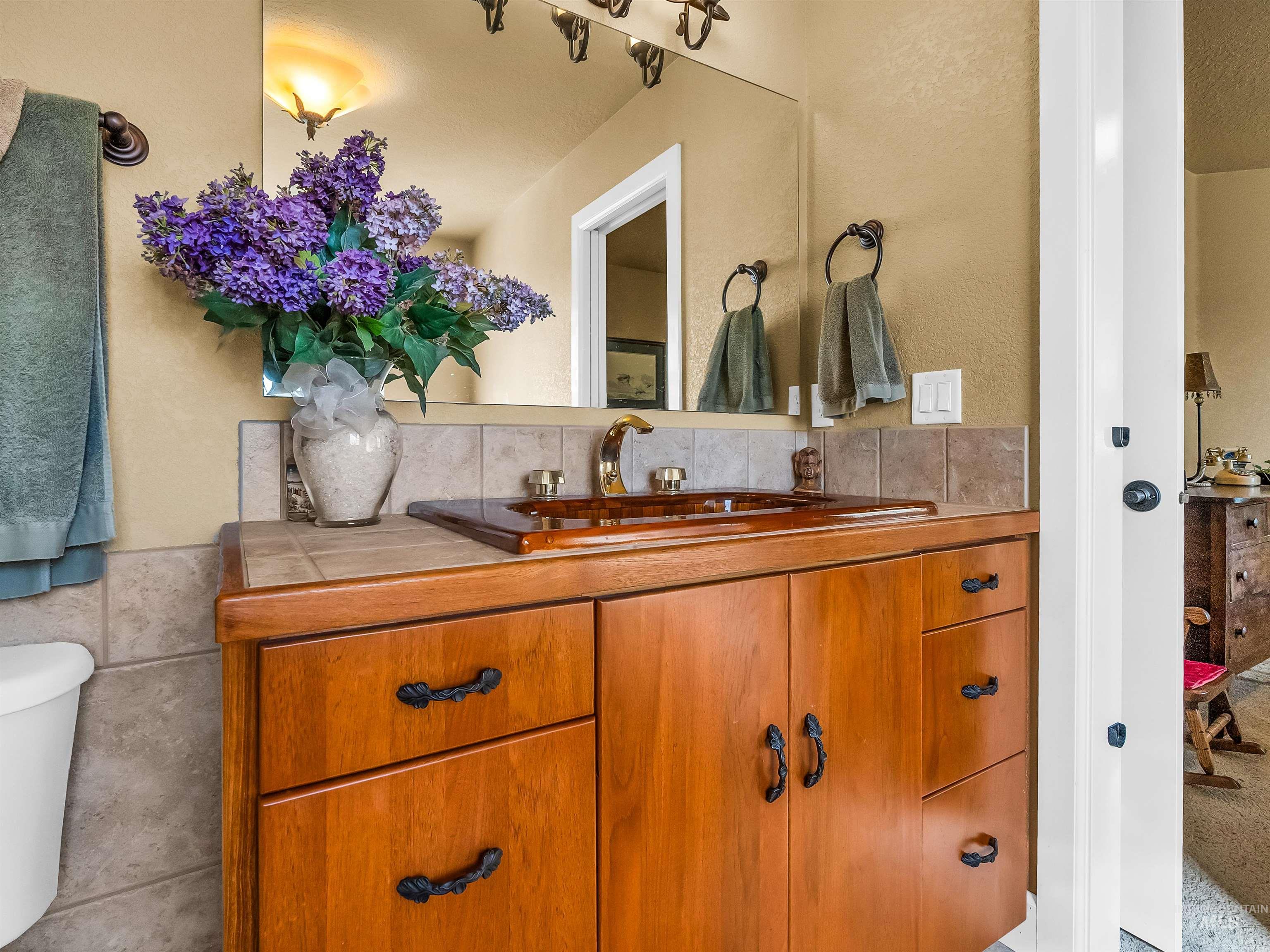 Half bathroom featuring vanity, tile walls, a textured wall, and tasteful backsplash