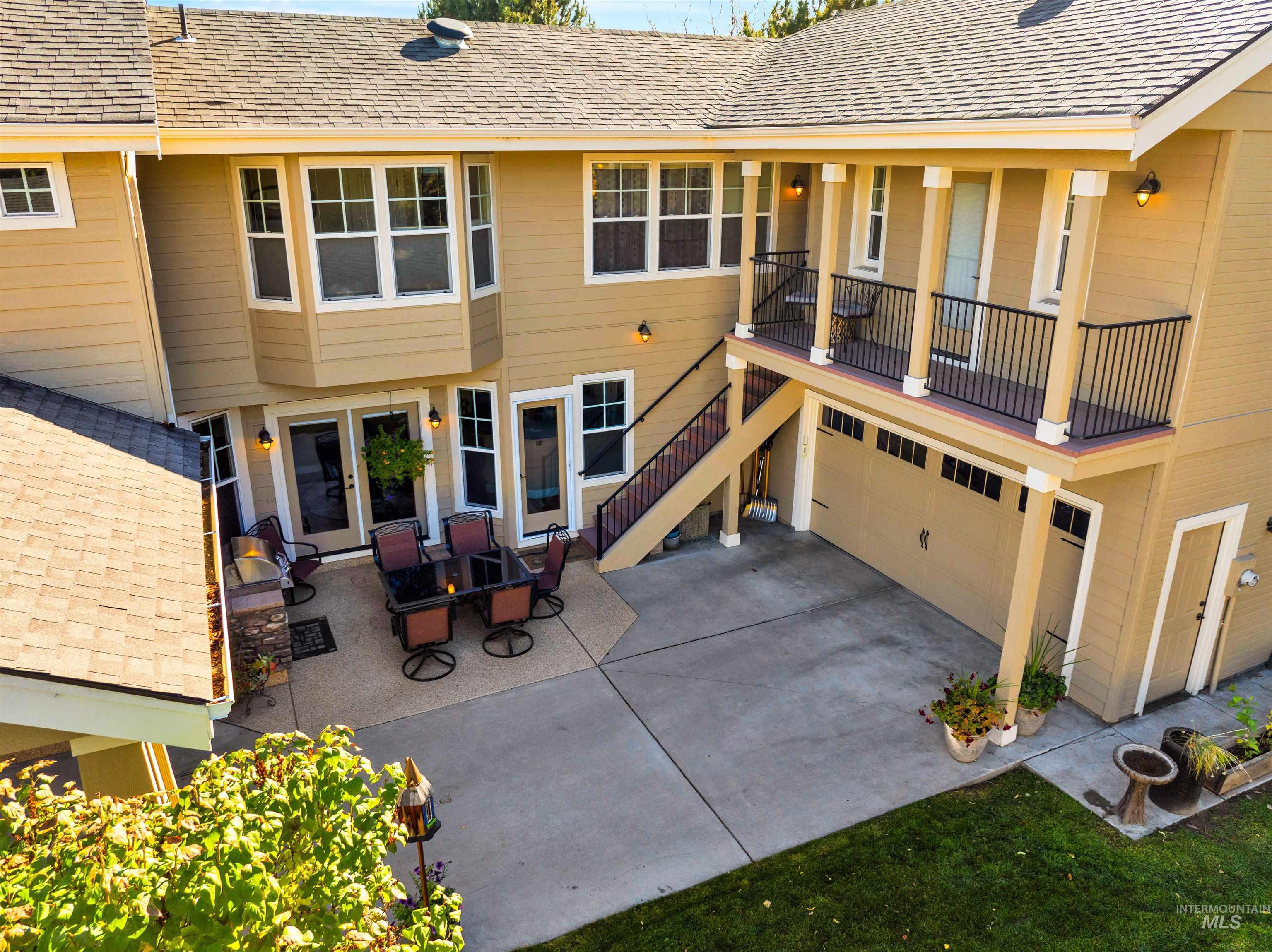 Back of house featuring a patio, stairs, and a shingled roof
