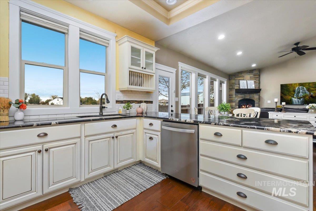 Kitchen with wood-style flooring, granite counters, custom built glass insert cabinets, and stainless steel appliances