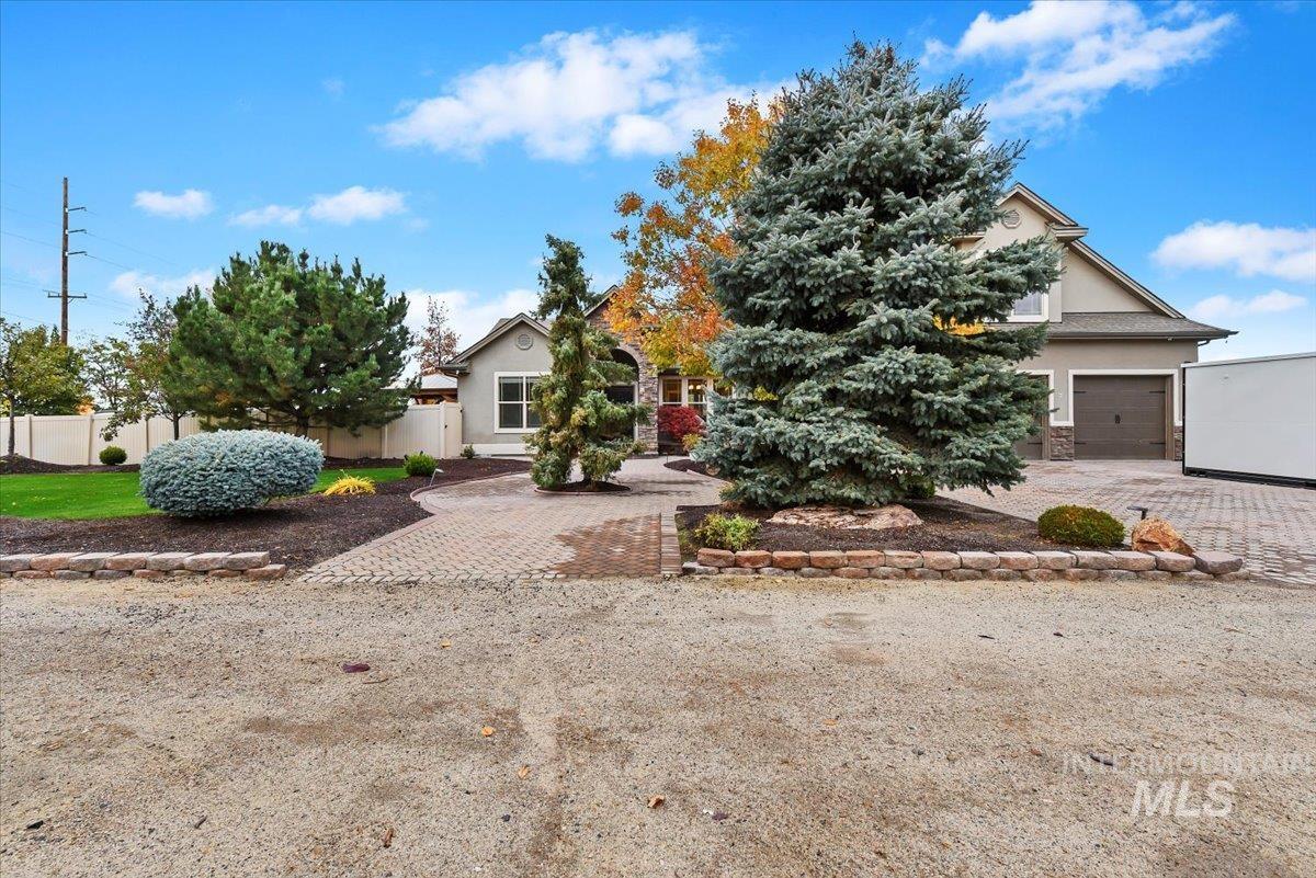 Obstructed view of property featuring stucco siding and decorative driveway