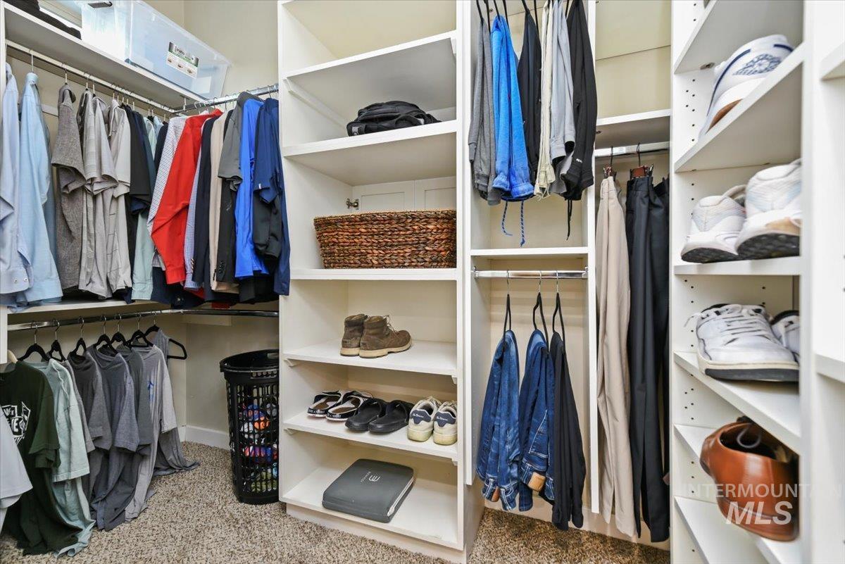 Spacious closet featuring light colored carpet