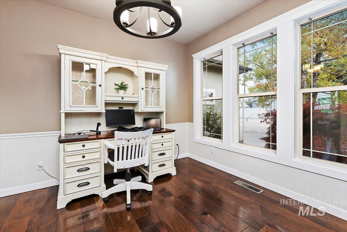 Home office with a chandelier and wood-style flooring