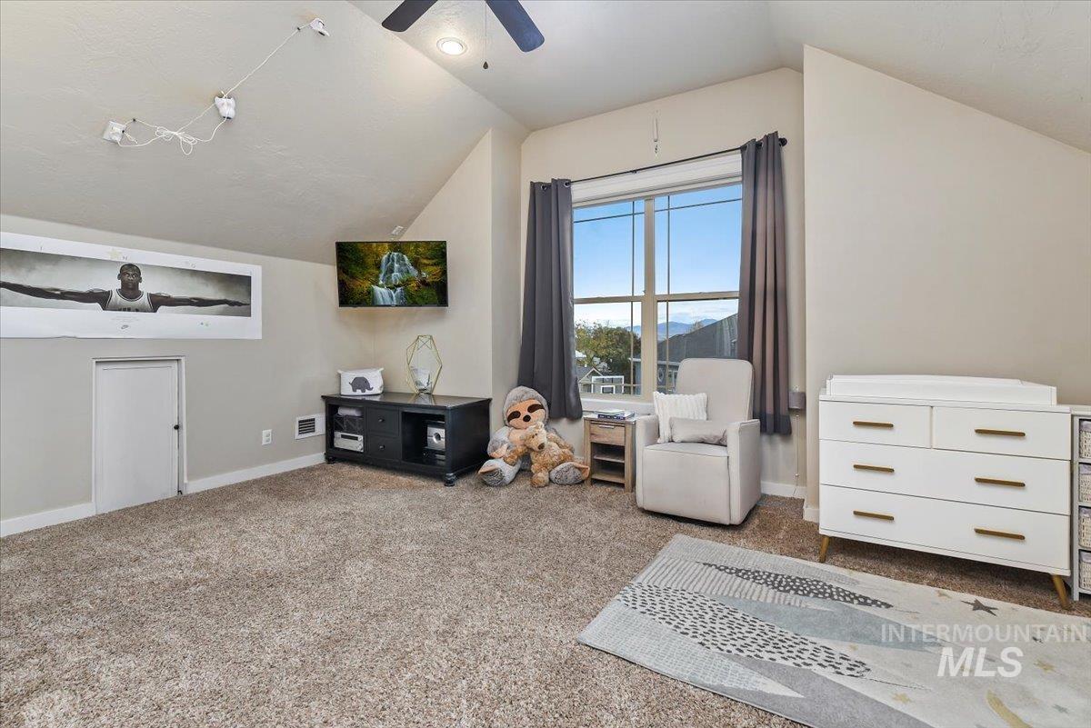 Roomy Bonus room featuring carpet, bathroom, lofted ceiling, ceiling fan and storage galore.