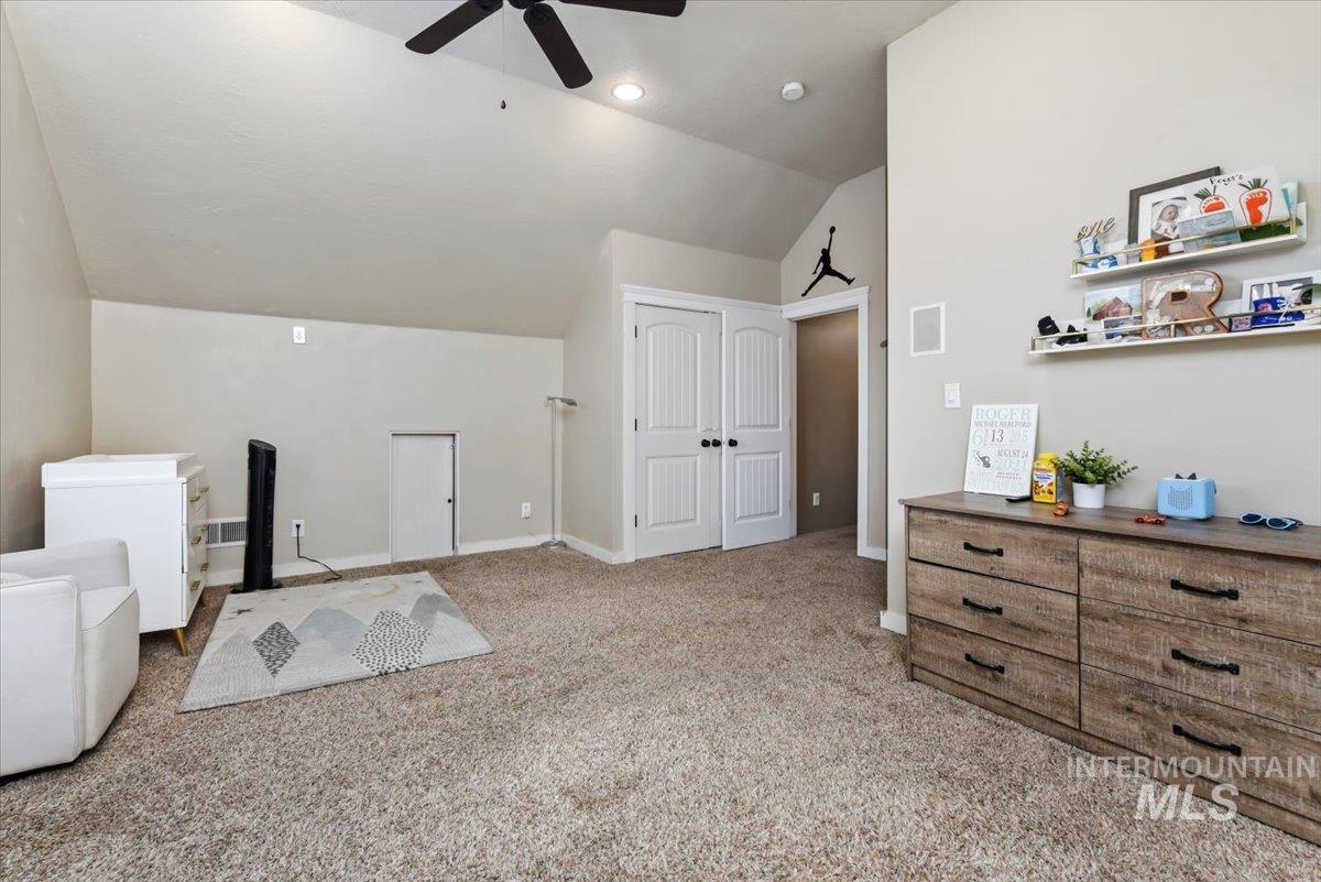 Bonus room featuring vaulted ceiling, light carpet, closet, bathroom and storage closets.