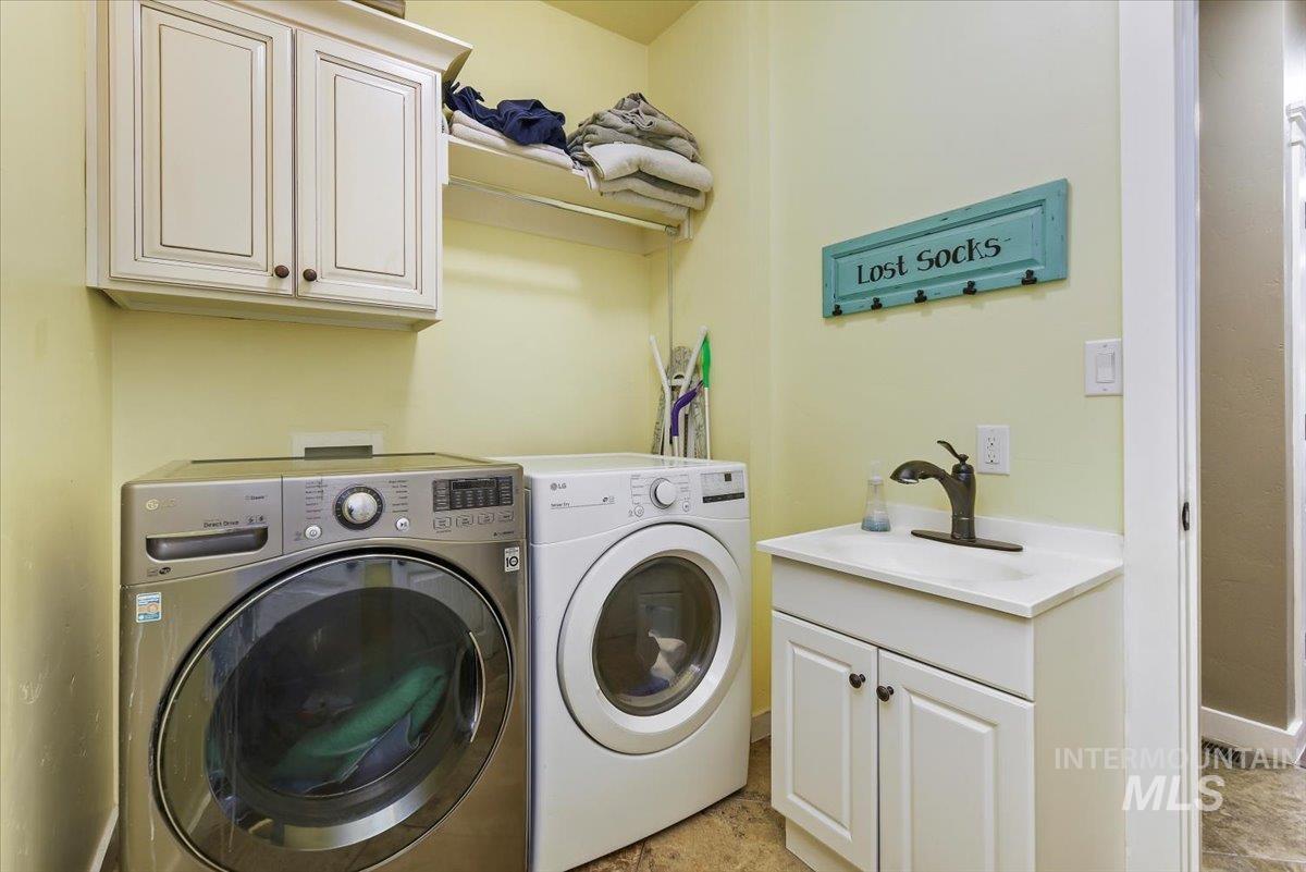 Washroom featuring cabinet space and washer and clothes dryer