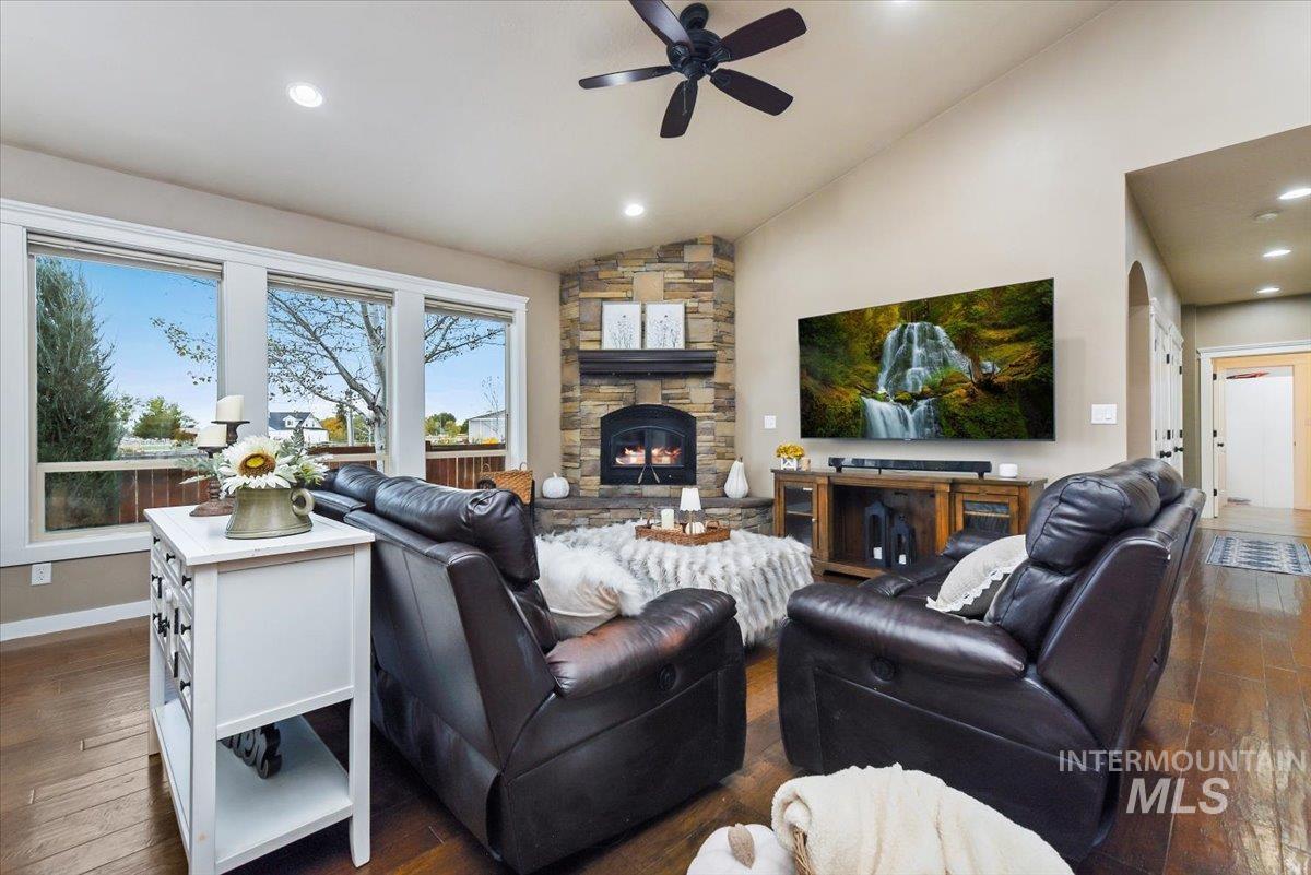 Cozy large Living area with wood-style flooring, recessed lighting, a fireplace, a ceiling fan, and vaulted ceiling