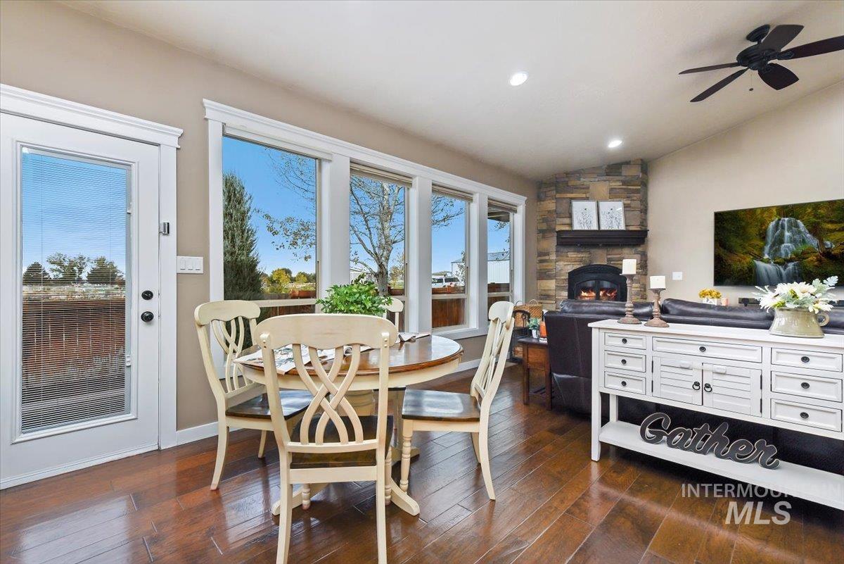 Dining area featuring vaulted ceiling, dark wood finished floors, recessed lighting.