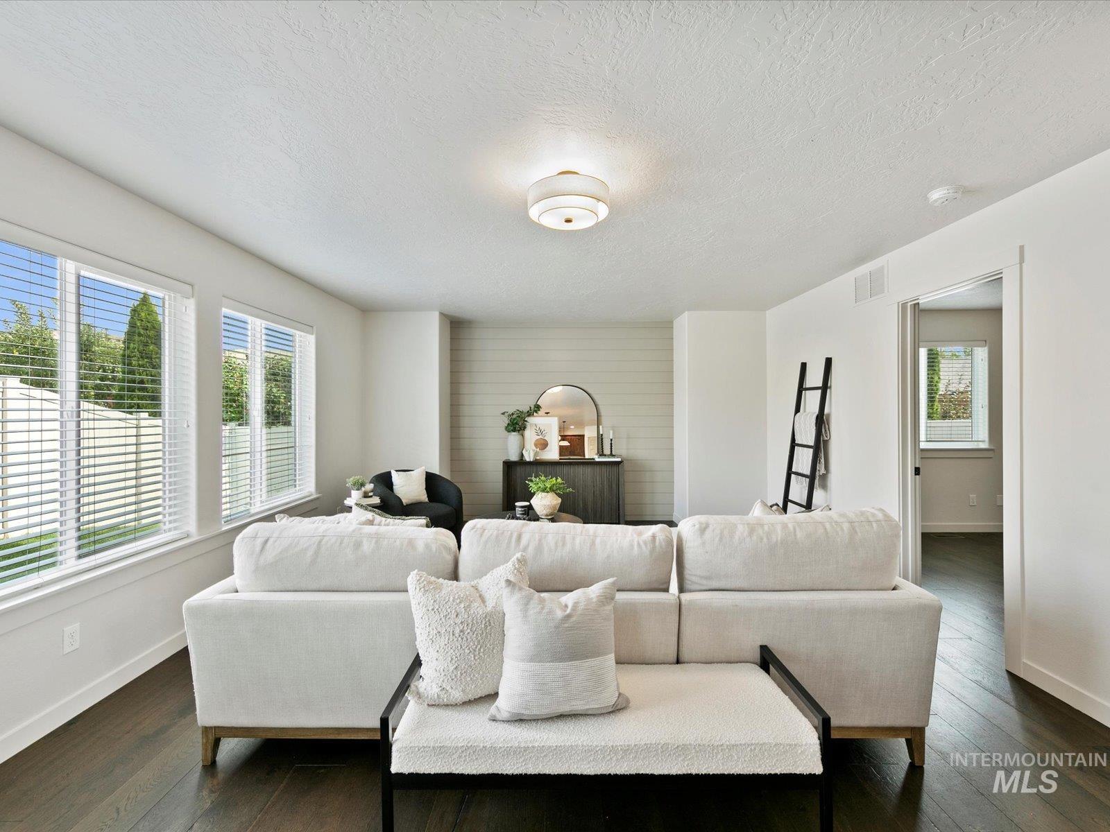 Living area featuring dark wood finished floors and a textured ceiling