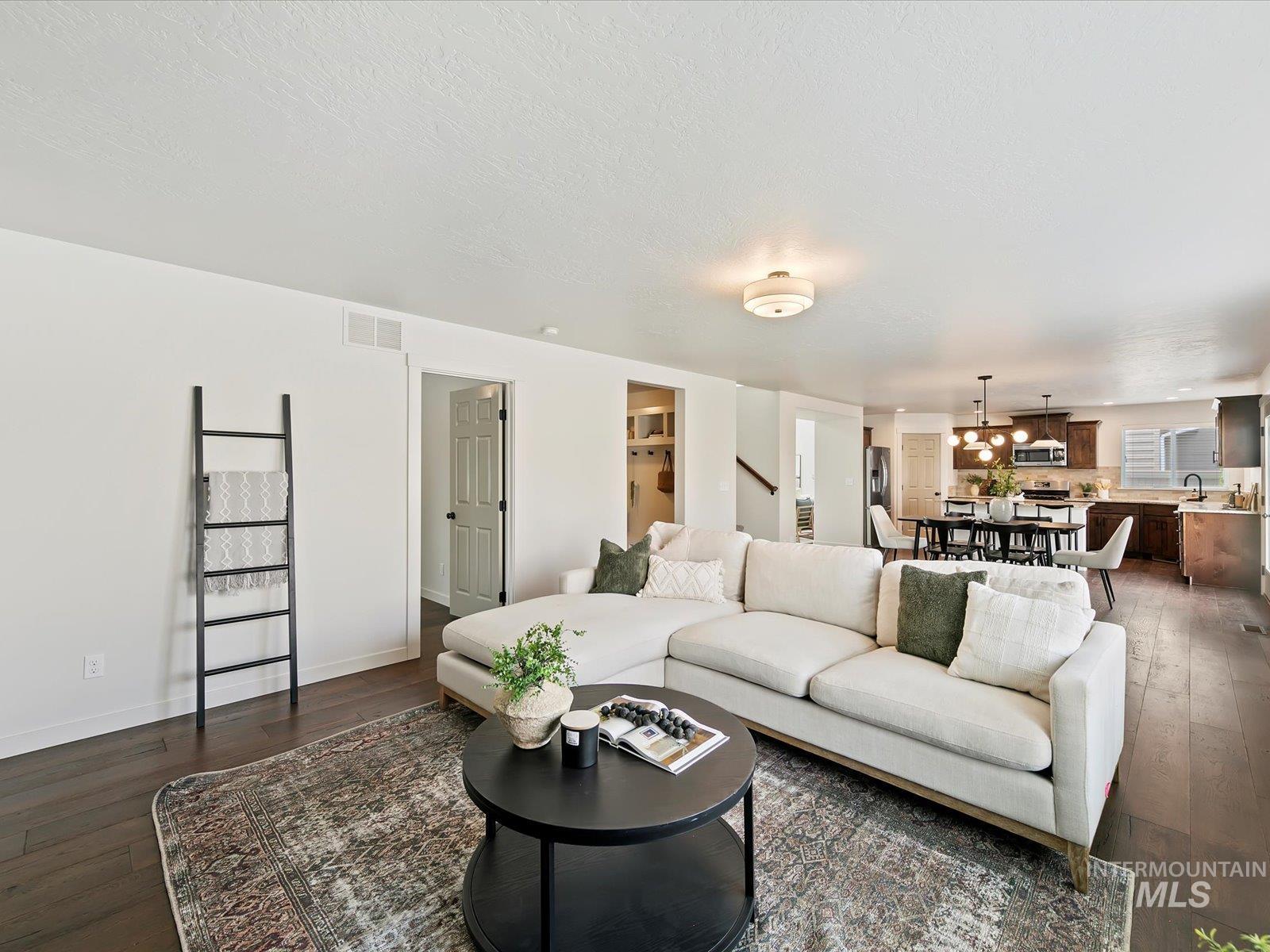 Living room featuring dark wood-style floors and a textured ceiling