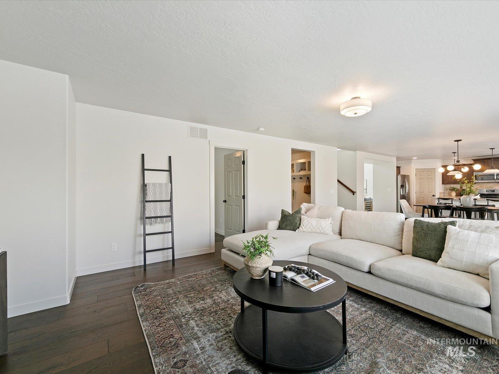 Living room with dark wood-style flooring and a textured ceiling