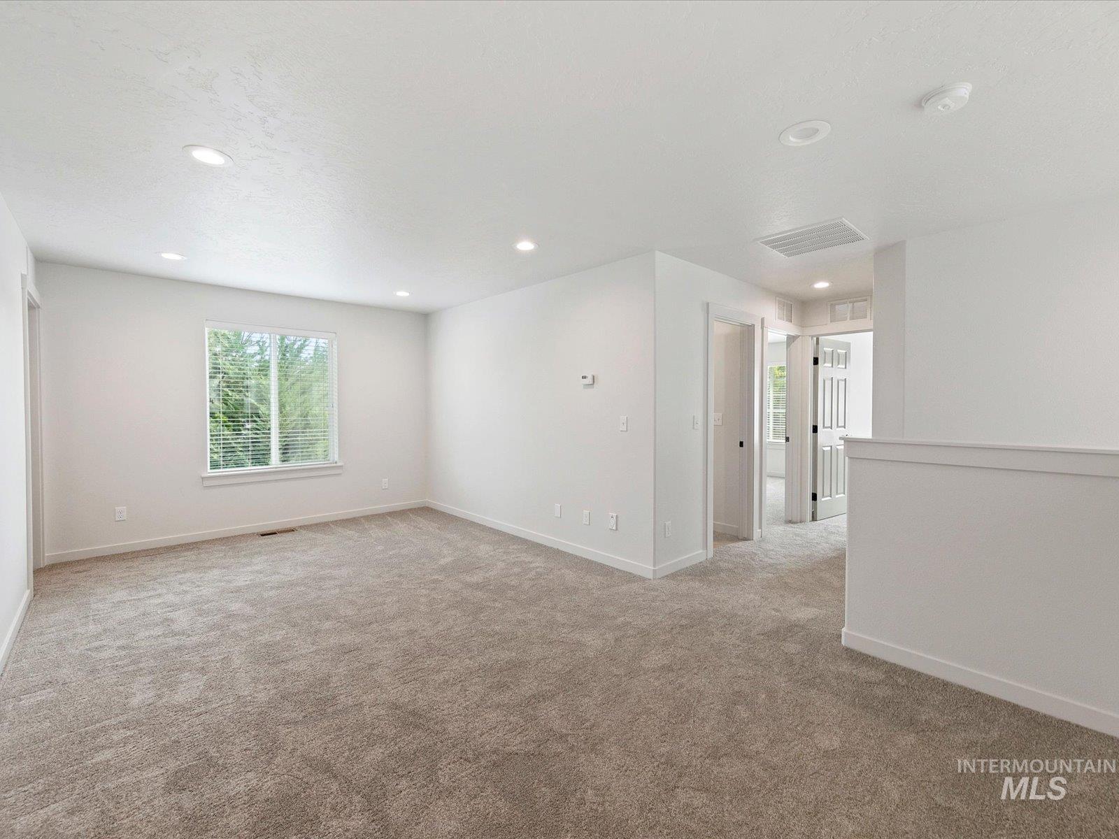 Empty room featuring light colored carpet and recessed lighting