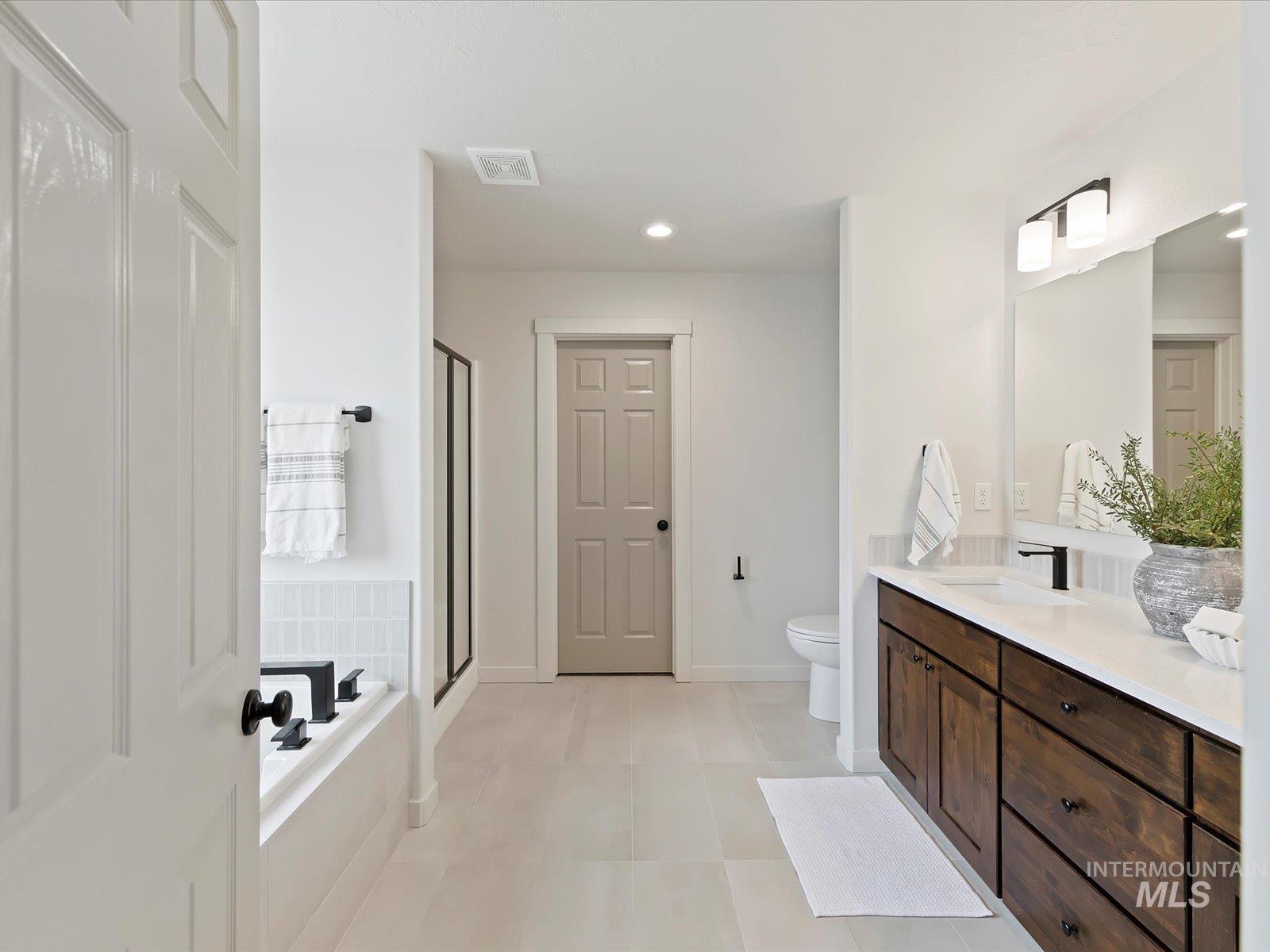 Bathroom featuring vanity, a garden tub, a shower stall, recessed lighting, and light tile patterned flooring