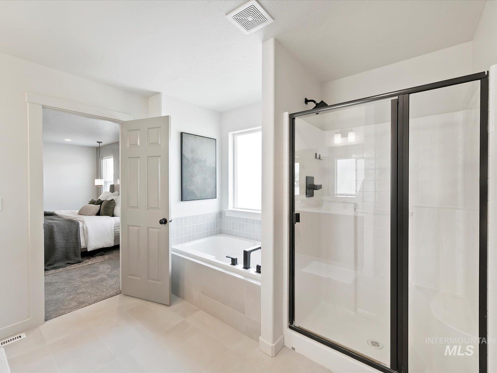 Bathroom featuring a shower stall, healthy amount of natural light, and a bath