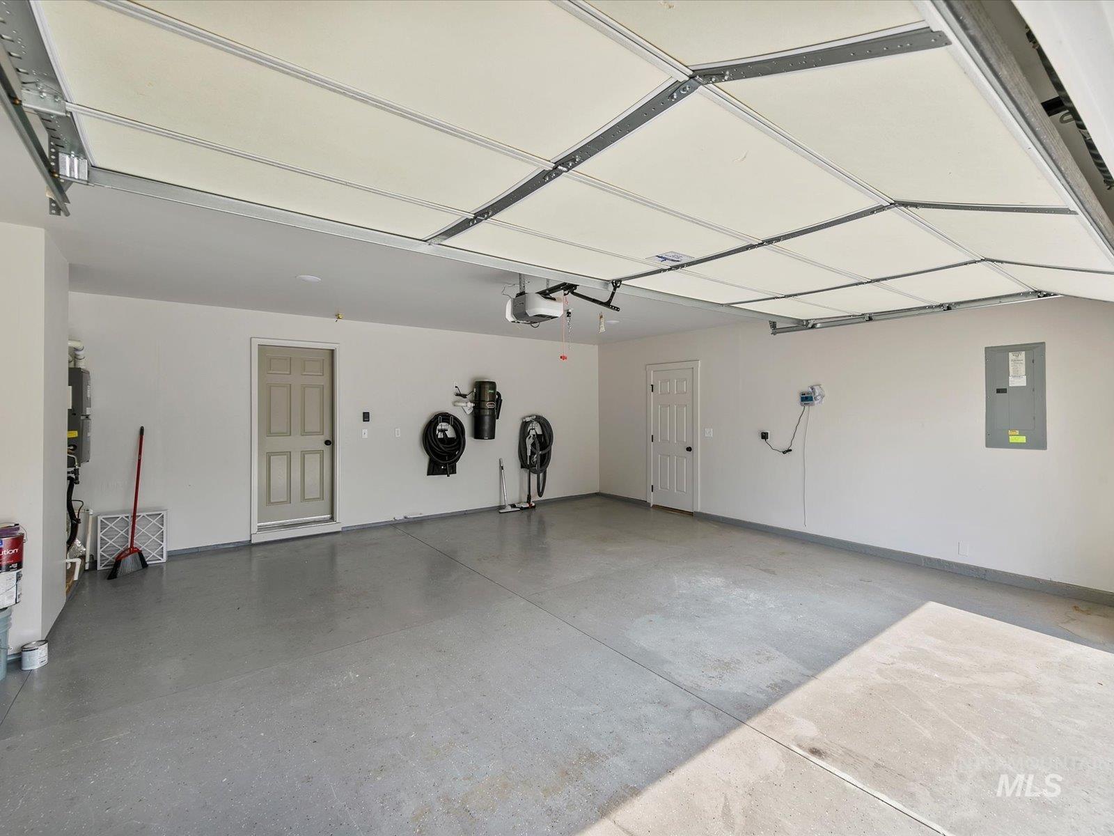 Garage featuring electric panel and a garage door opener