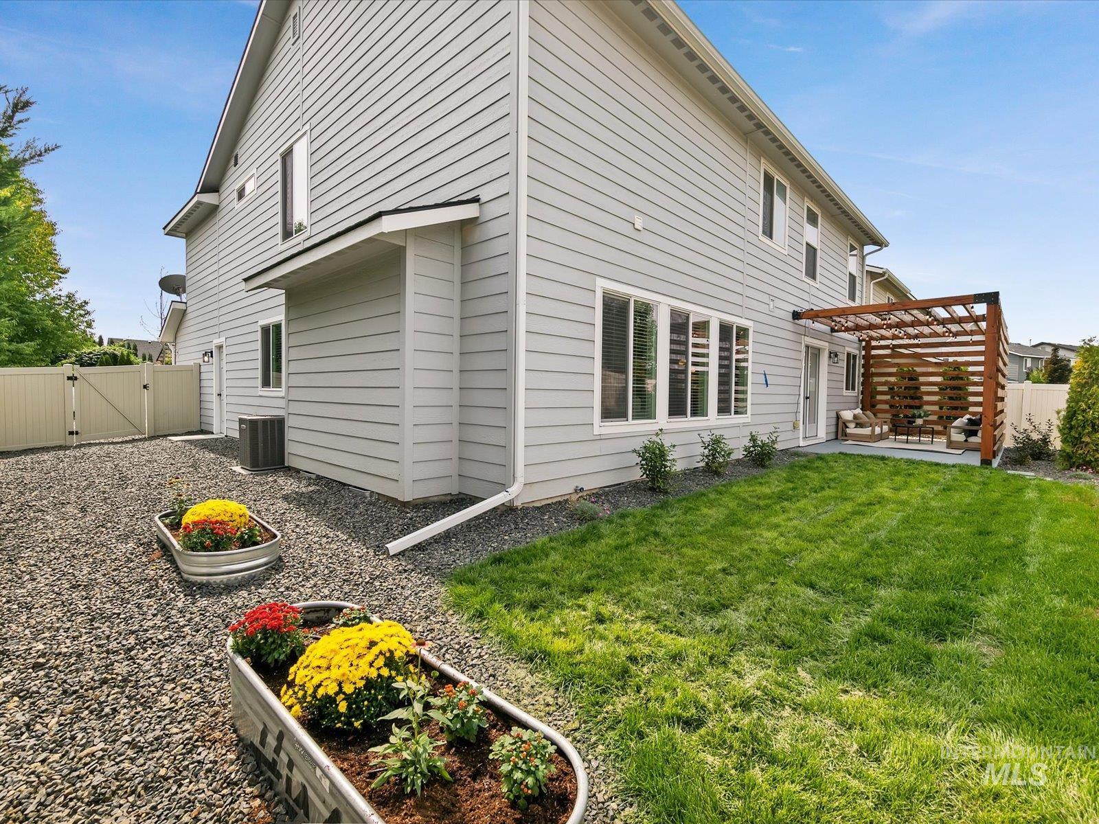 Rear view of property with a gate, a pergola, and a patio area