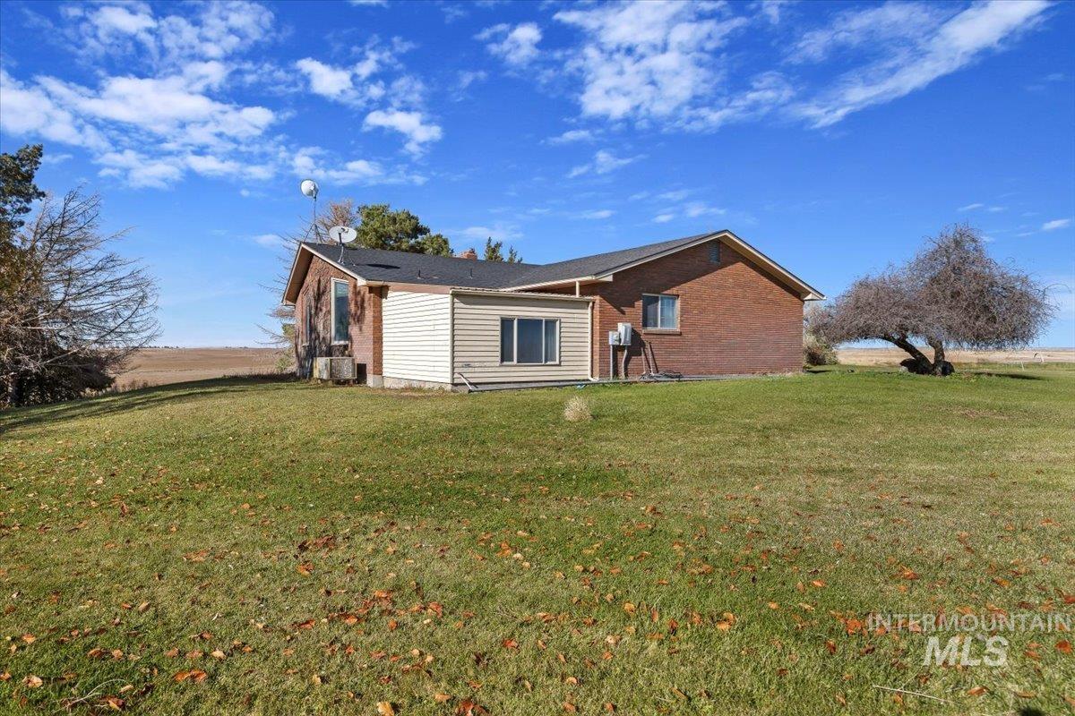 View of side of home featuring a yard and brick siding
