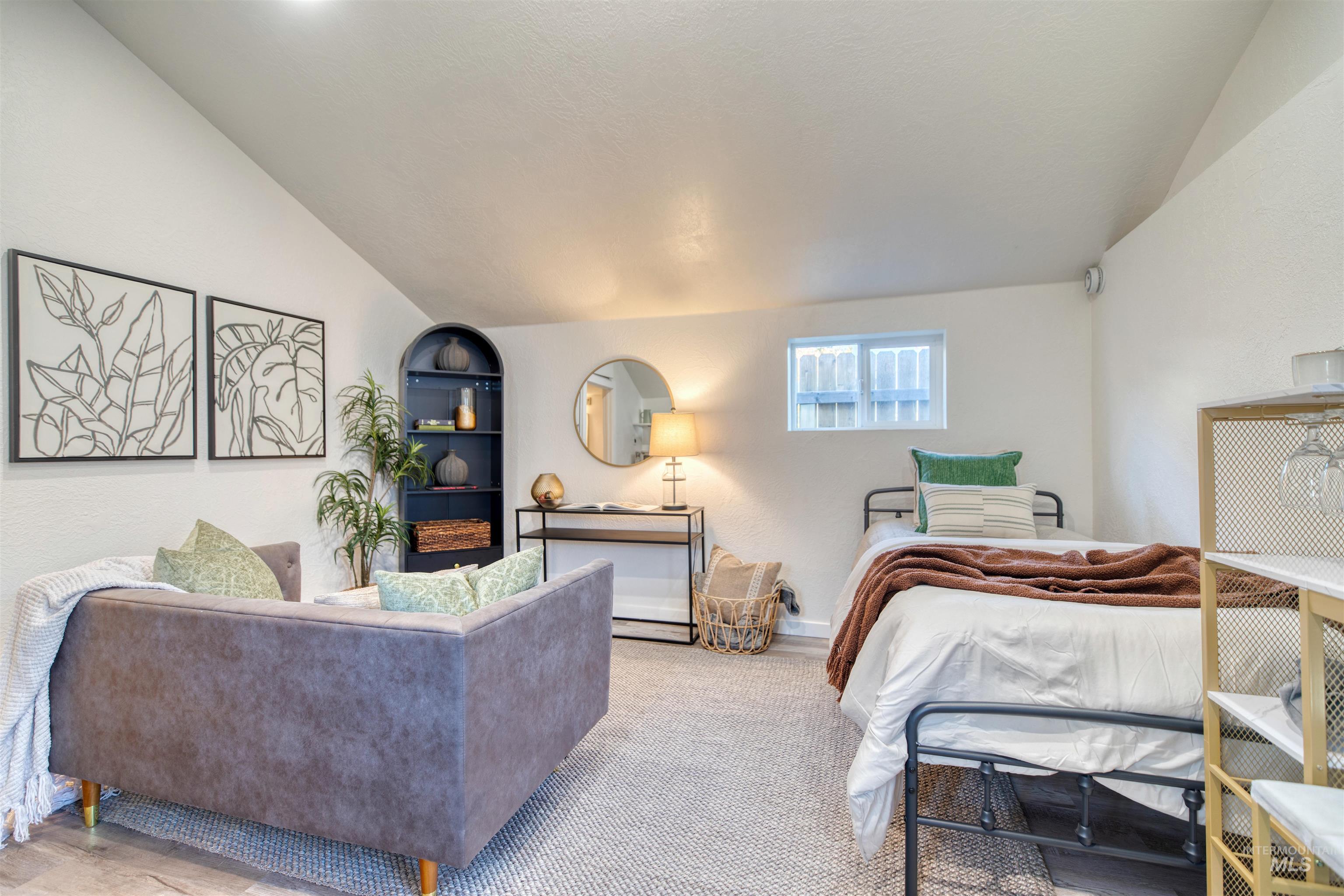Bedroom featuring vaulted ceiling and baseboards