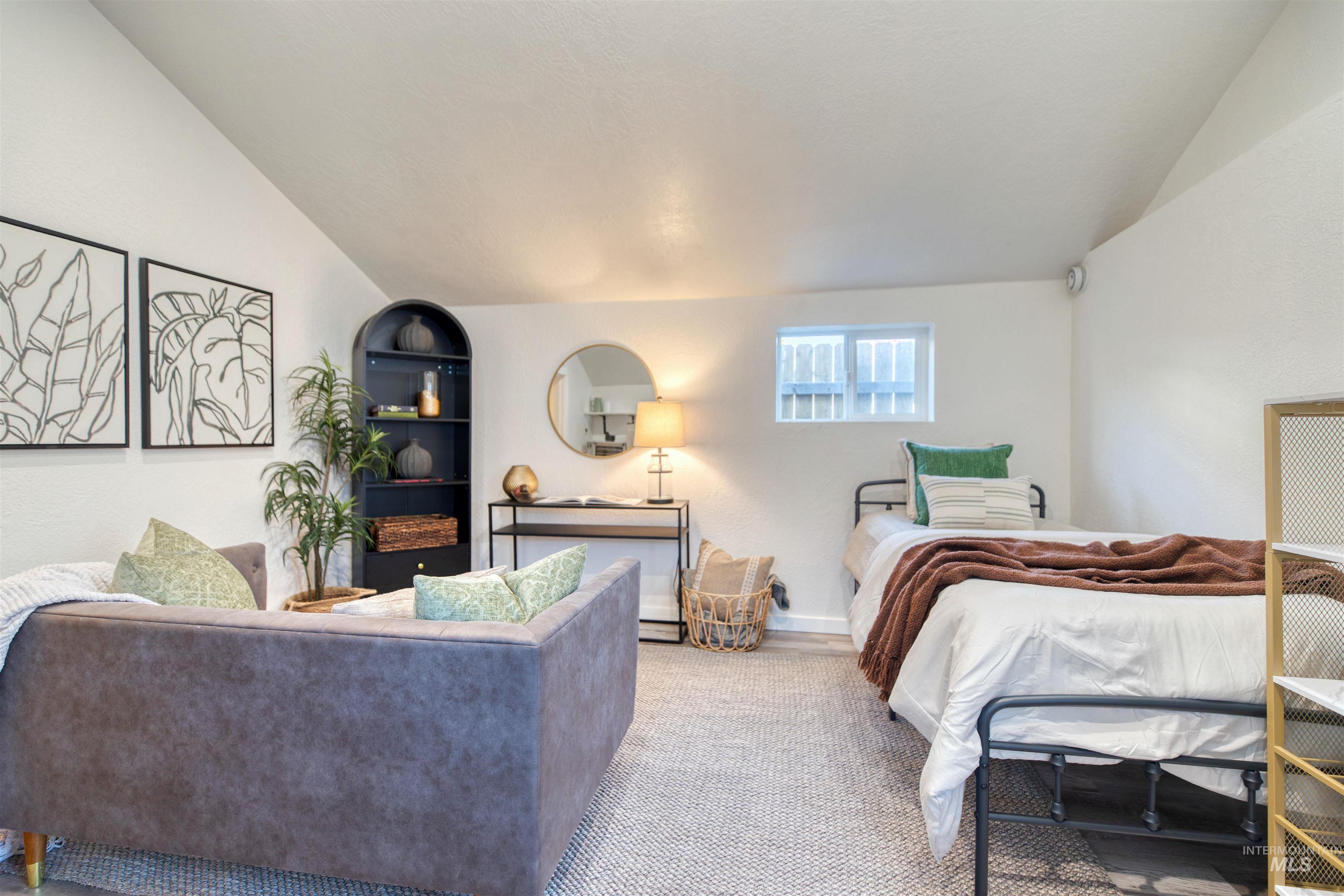 Bedroom with lofted ceiling and baseboards