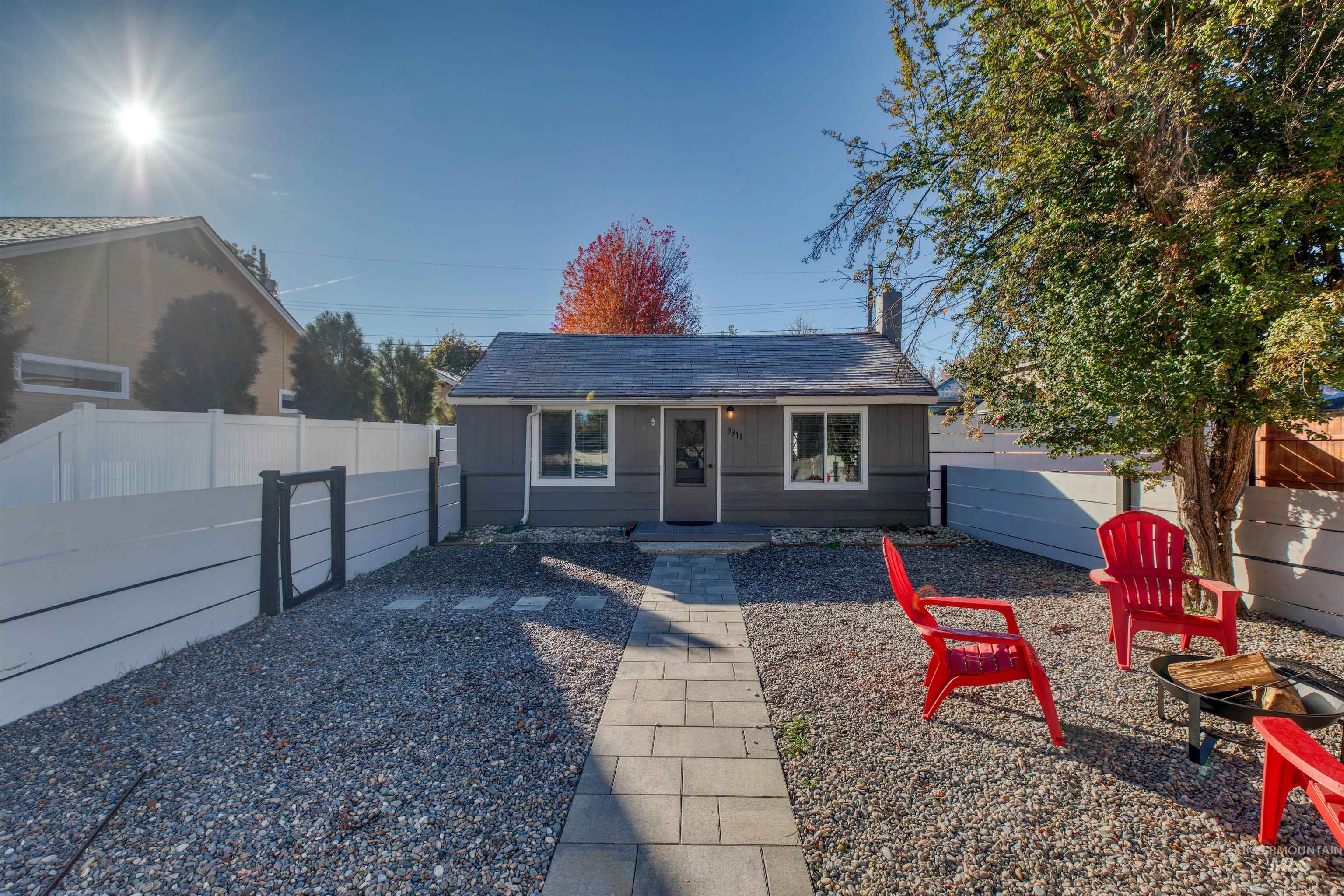 Bungalow with a porch, a fenced backyard, and a shingled roof
