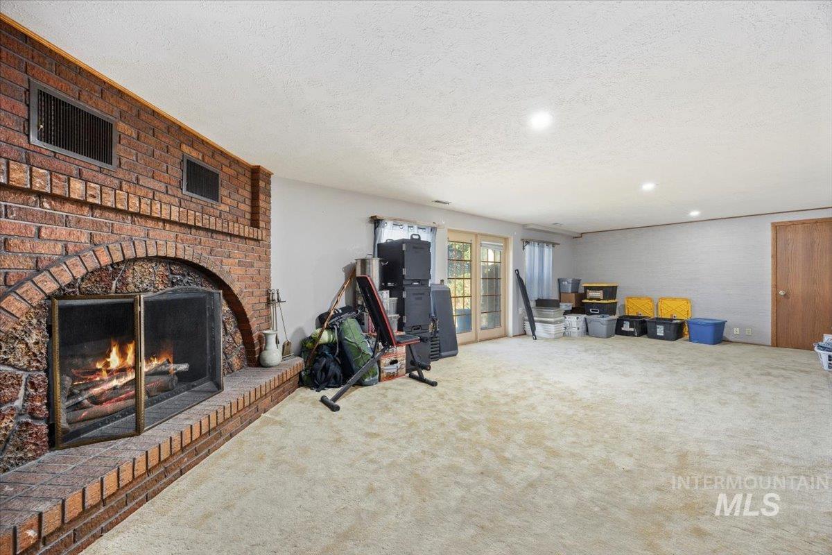 Interior space with a textured ceiling, carpet, a fireplace, and recessed lighting